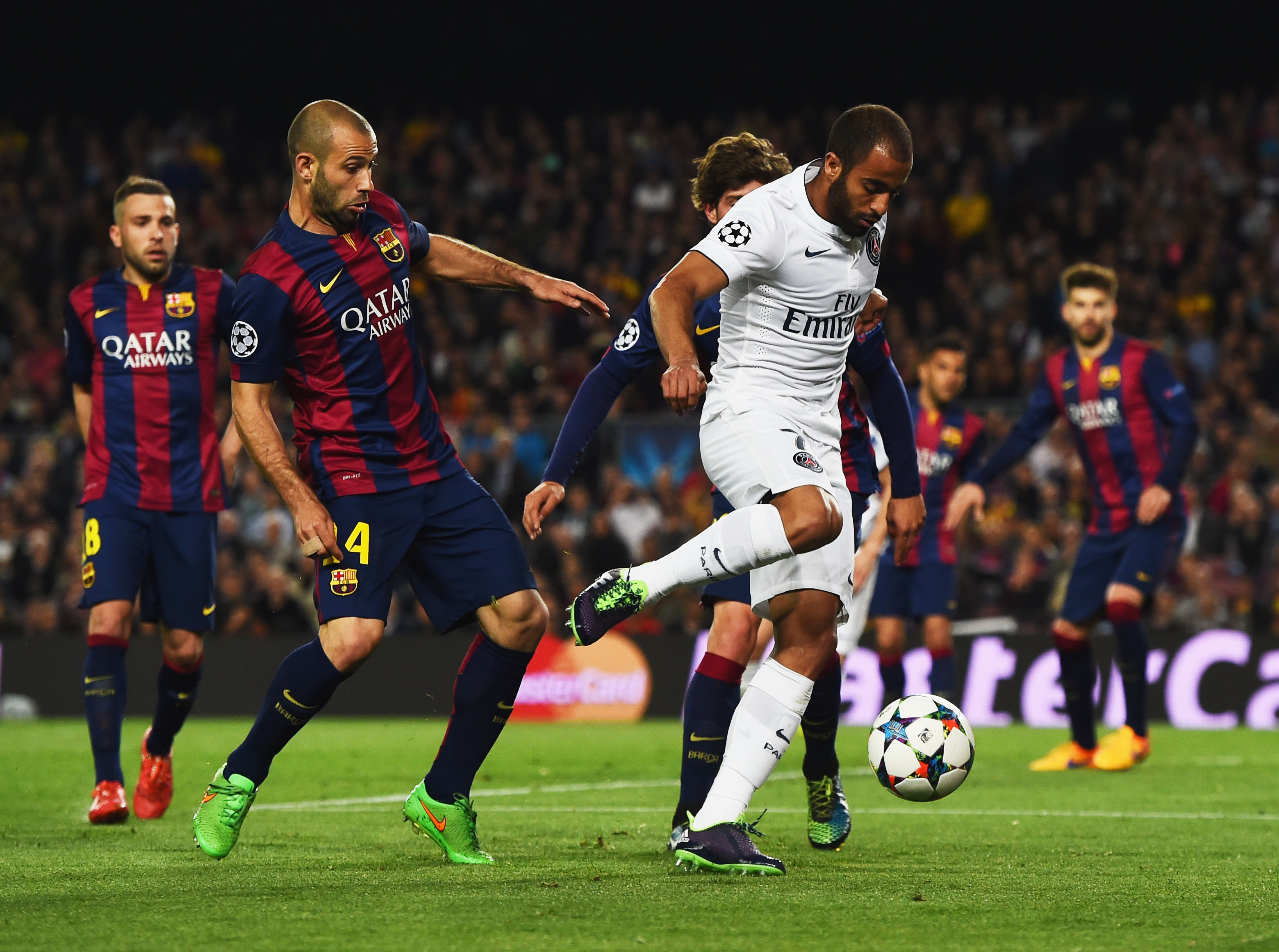 BARCELONA, SPAIN - APRIL 21:  Lucas of PSG takes on Javier Mascherano and Sergi Roberto of Barcelona during the UEFA Champions League Quarter Final second leg match between FC Barcelona and Paris Saint-Germain at Camp Nou on April 21, 2015 in Barcelona, Spain.  (Photo by David Ramos/Getty Images)