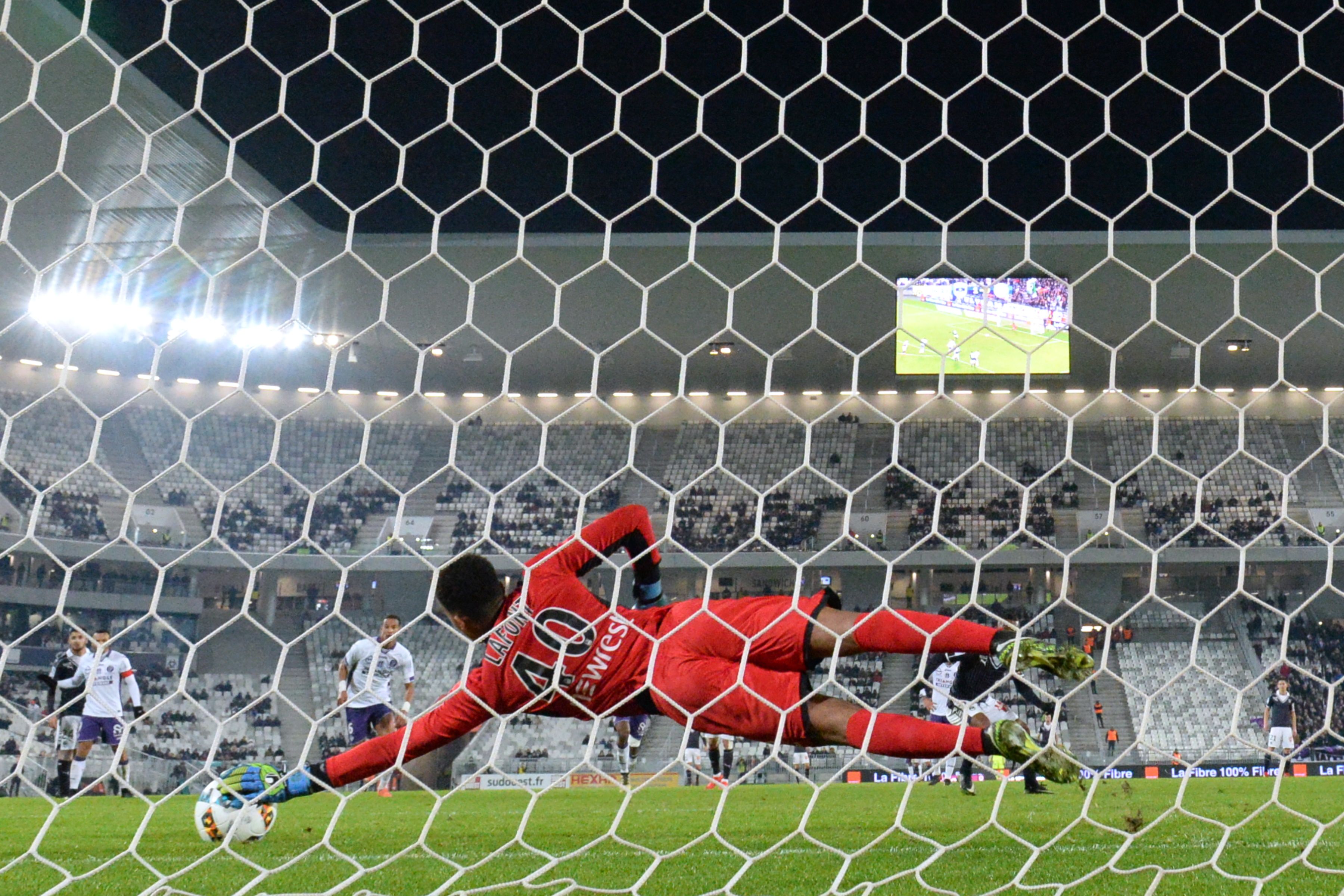 TOPSHOT - Toulouse's French goalkeeper Alban Lafont stops a penalty during the French L1 football match between Bordeaux (FCGB) and Toulouse (TFC) on January 21, 2017, at the Matmut Atlantique stadium in Bordeaux, southwestern France. / AFP / NICOLAS TUCAT        (Photo credit should read NICOLAS TUCAT/AFP/Getty Images)