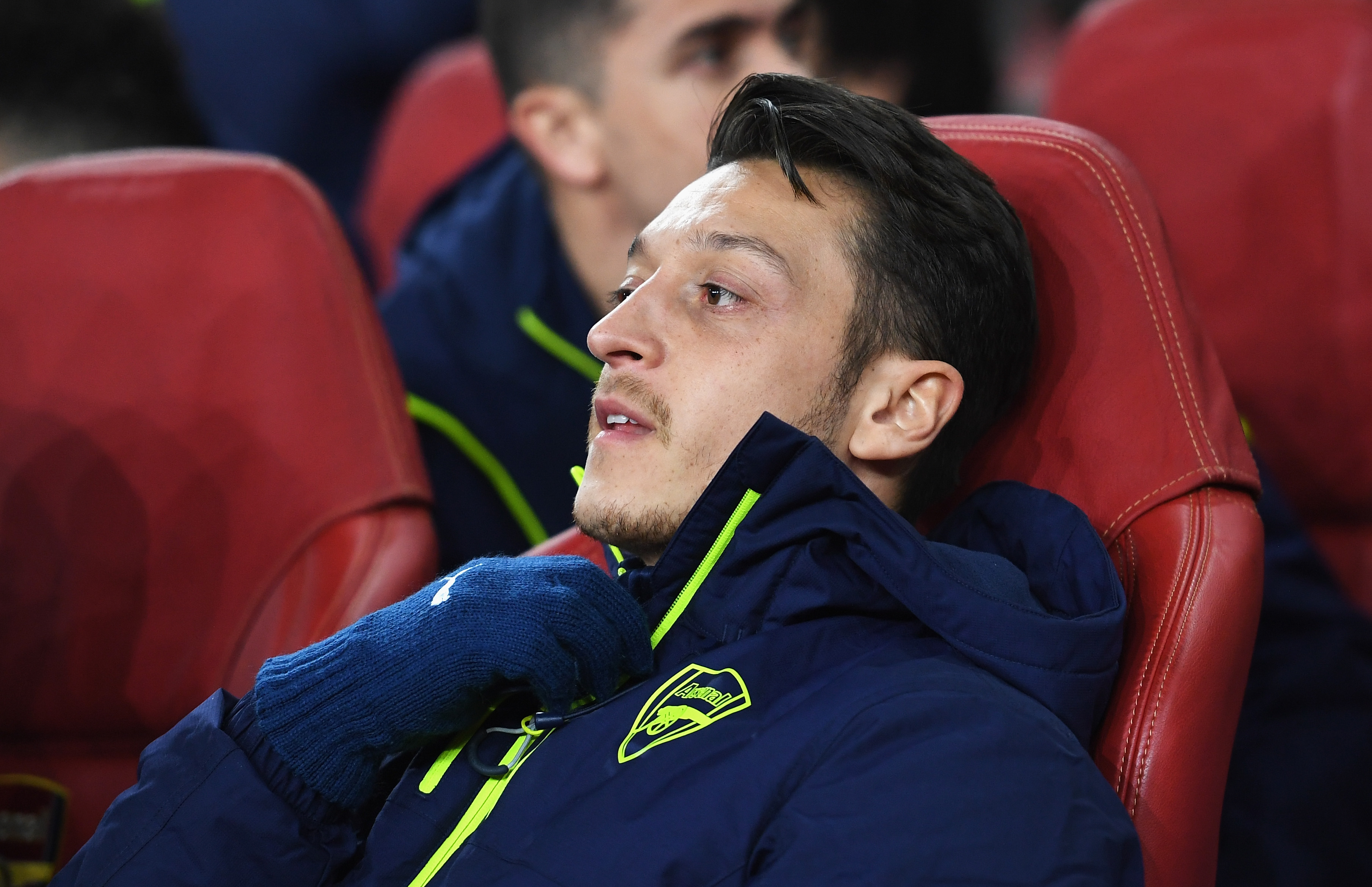 LONDON, ENGLAND - MARCH 07:  Mesut Oezil of Arsenal looks on from the bench prior to the UEFA Champions League Round of 16 second leg match between Arsenal FC and FC Bayern Muenchen at Emirates Stadium on March 7, 2017 in London, United Kingdom.  (Photo by Shaun Botterill/Getty Images)