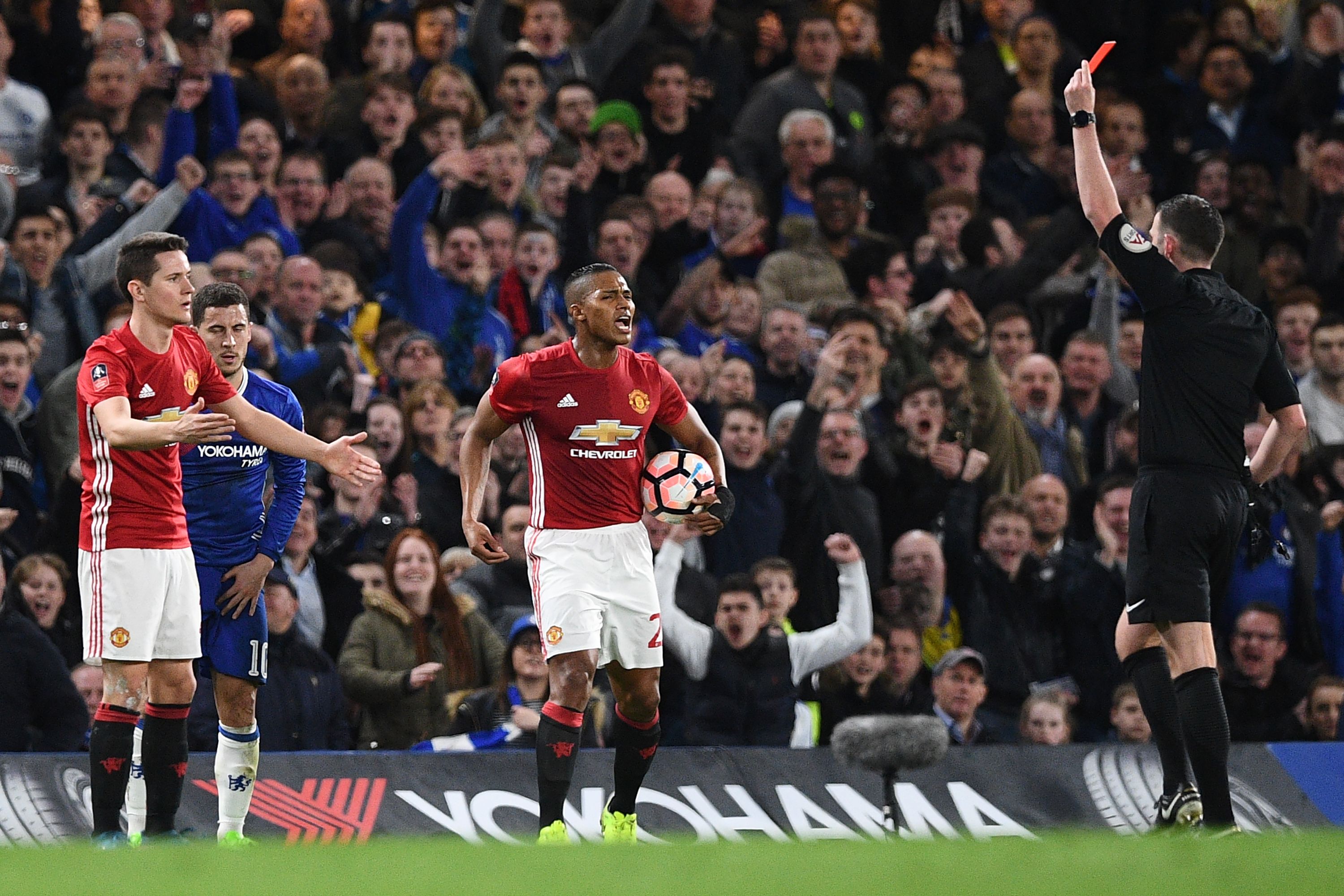 English referee Michael Oliver (R) shows a red card for a second bookable offence, to Manchester United's Spanish midfielder Ander Herrera (L) during the English FA Cup quarter final football match between Chelsea and Manchester United at Stamford Bridge in London on March 13, 2017. / AFP PHOTO / Justin TALLIS / RESTRICTED TO EDITORIAL USE. No use with unauthorized audio, video, data, fixture lists, club/league logos or 'live' services. Online in-match use limited to 75 images, no video emulation. No use in betting, games or single club/league/player publications.  /         (Photo credit should read JUSTIN TALLIS/AFP/Getty Images)