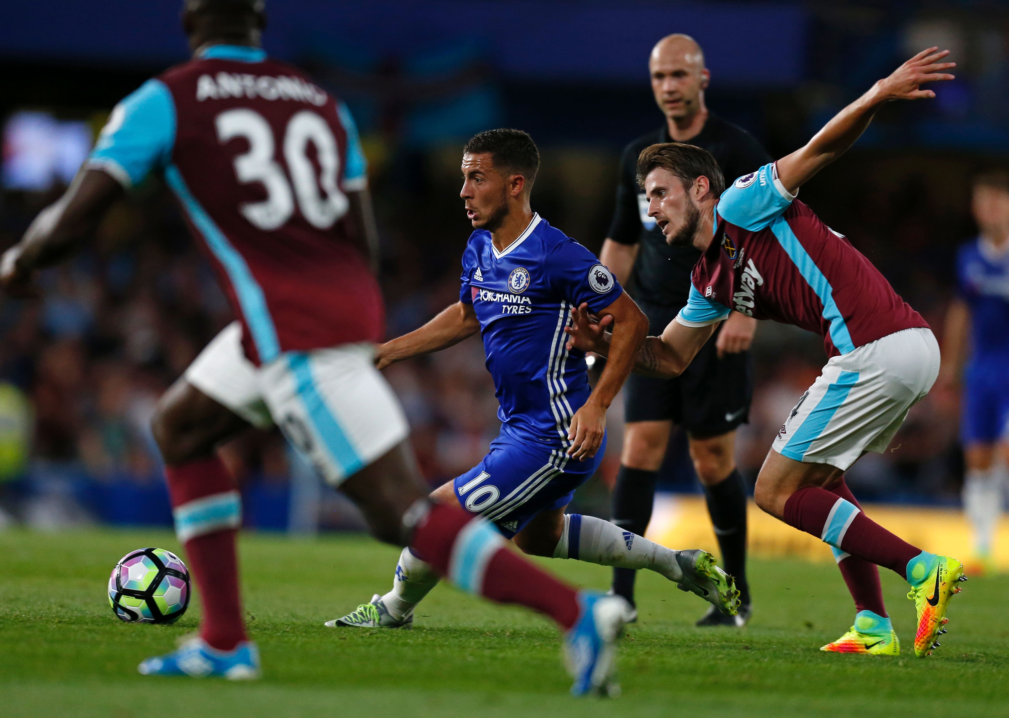Chelsea's Belgian midfielder Eden Hazard weaves his way past West Ham United's Norwegian midfielder Havard Nordtveit (R) during the English Premier League football match between Chelsea and West Ham United at Stamford Bridge in London on August 15, 2016. / AFP / Ian KINGTON / RESTRICTED TO EDITORIAL USE. No use with unauthorized audio, video, data, fixture lists, club/league logos or 'live' services. Online in-match use limited to 75 images, no video emulation. No use in betting, games or single club/league/player publications.  /         (Photo credit should read IAN KINGTON/AFP/Getty Images)