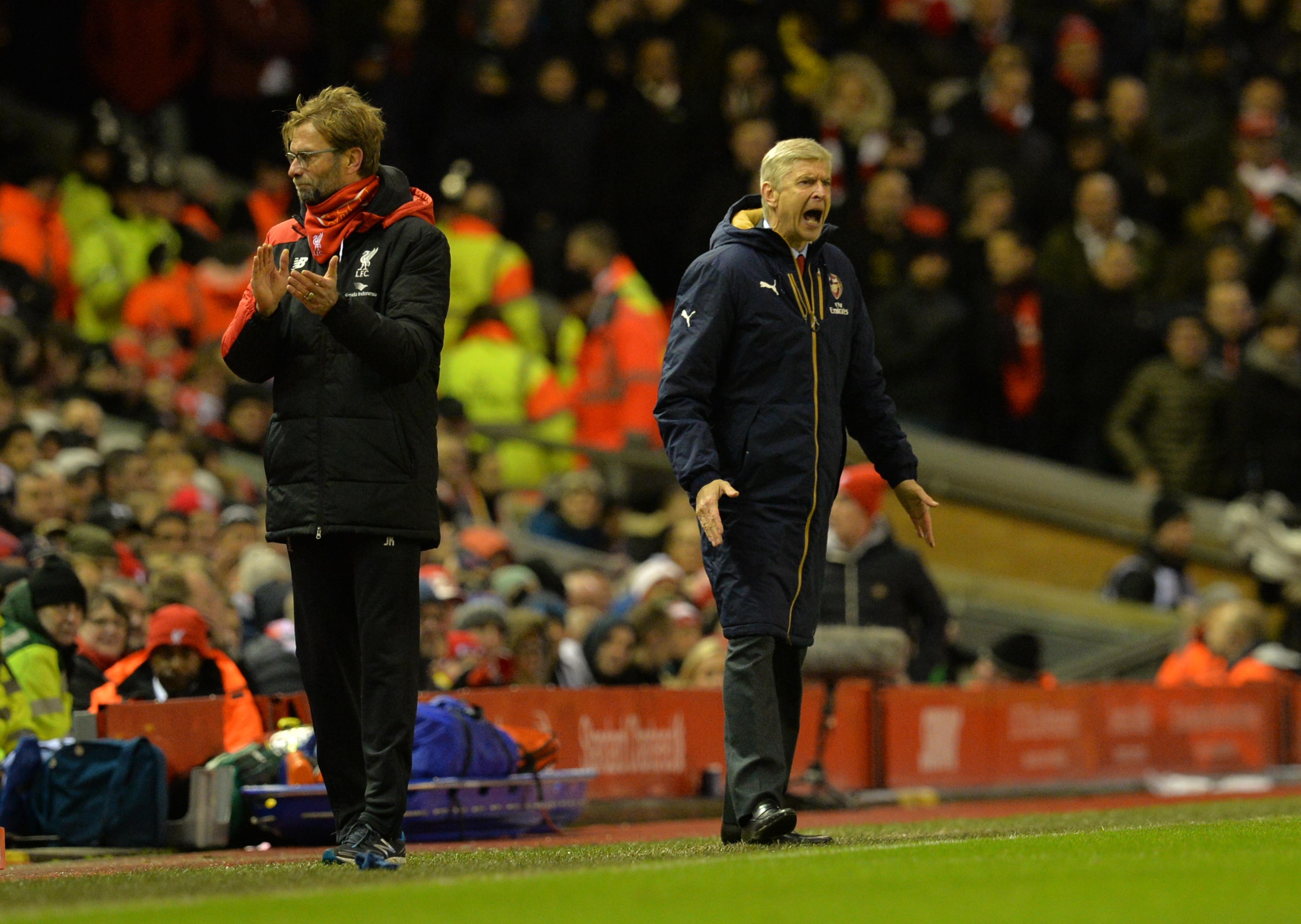 Liverpool's German manager Jurgen Klopp (L) and Arsenal's French manager Arsene Wenger react during the English Premier League football match between Liverpool and Arsenal at Anfield stadium in Liverpool, north-west England on January 13, 2016.
AFP PHOTO / PAUL ELLIS
RESTRICTED TO EDITORIAL USE. NO USE WITH UNAUTHORIZED AUDIO, VIDEO, DATA, FIXTURE LISTS, CLUB/LEAGUE LOGOS OR 'LIVE' SERVICES. ONLINE IN-MATCH USE LIMITED TO 75 IMAGES, NO VIDEO EMULATION. NO USE IN BETTING, GAMES OR SINGLE CLUB/LEAGUE/PLAYER PUBLICATIONS. / AFP / PAUL ELLIS        (Photo credit should read PAUL ELLIS/AFP/Getty Images)