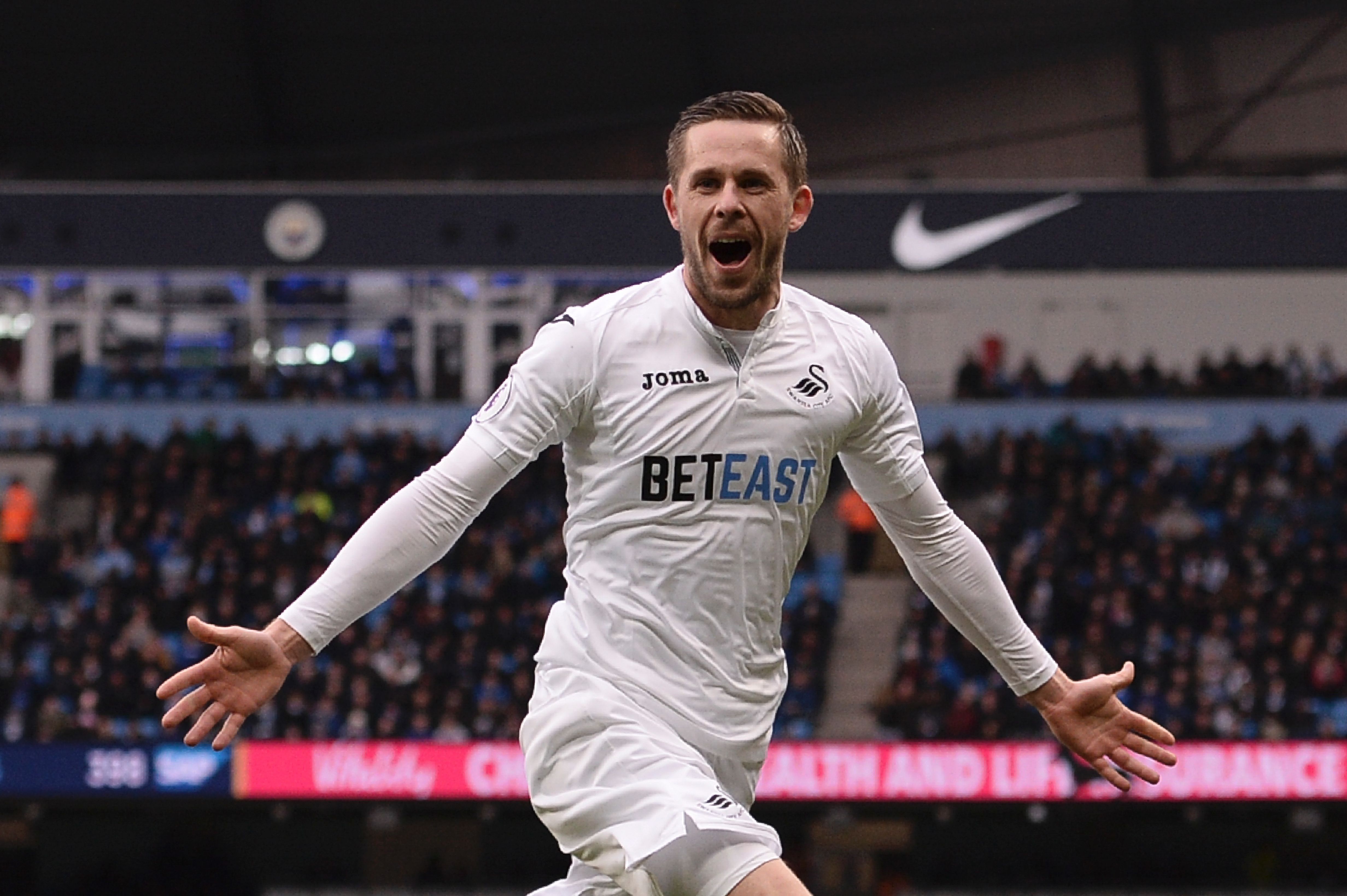 Swansea City's Icelandic midfielder Gylfi Sigurdsson celebrates after scoring their first goal during the English Premier League football match between Manchester City and Swansea City at the Etihad Stadium in Manchester, north west England, on February 5, 2017. / AFP / Oli SCARFF / RESTRICTED TO EDITORIAL USE. No use with unauthorized audio, video, data, fixture lists, club/league logos or 'live' services. Online in-match use limited to 75 images, no video emulation. No use in betting, games or single club/league/player publications.  /         (Photo credit should read OLI SCARFF/AFP/Getty Images)