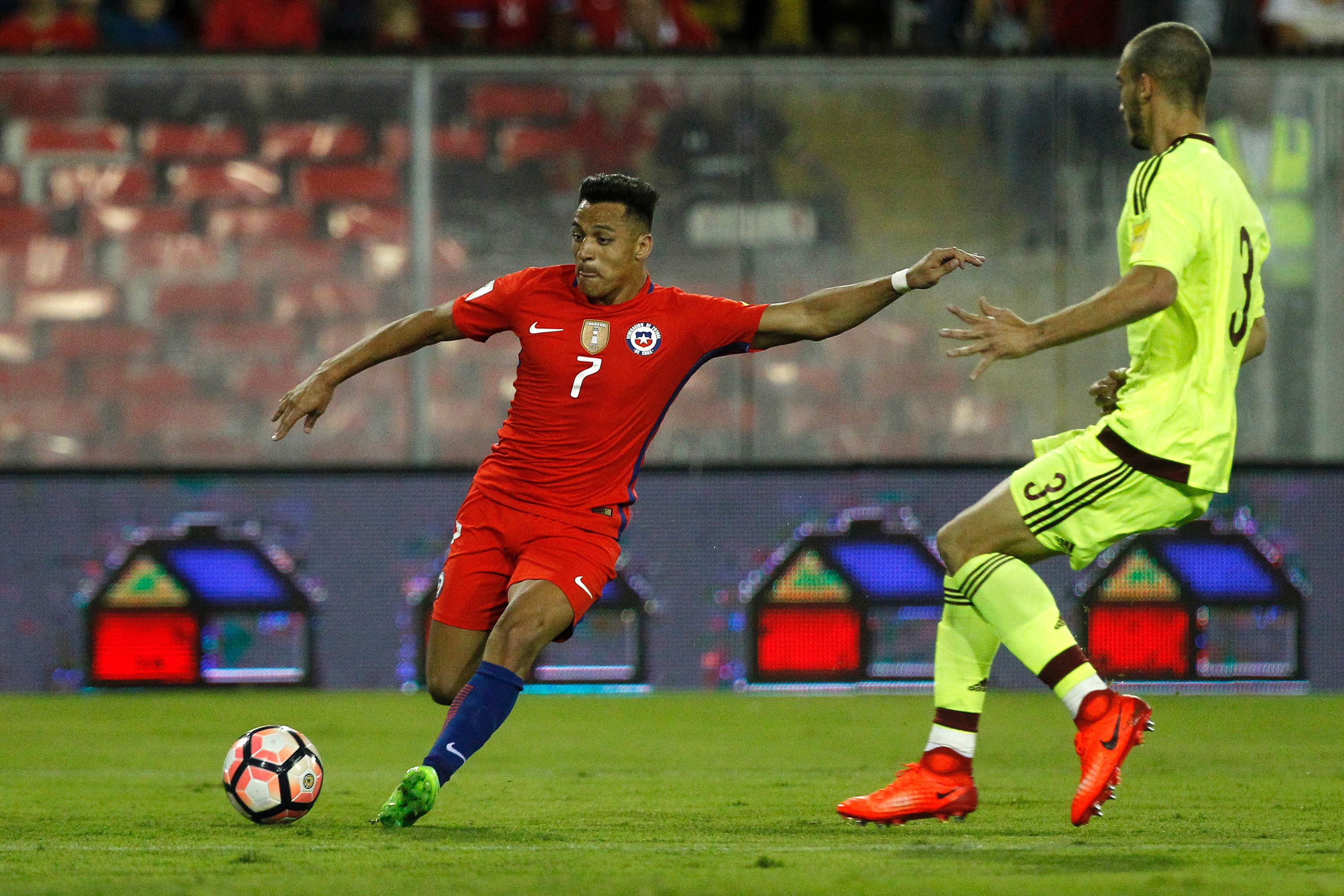 Chile's forward Alexis Sanchez (L) prepares to kick the ball next to Venezuela's defender Mike Villanueva during their 2018 FIFA World Cup qualifier football match in Santiago, Chile on March 28, 2017. / AFP PHOTO / Claudio Reyes        (Photo credit should read CLAUDIO REYES/AFP/Getty Images)