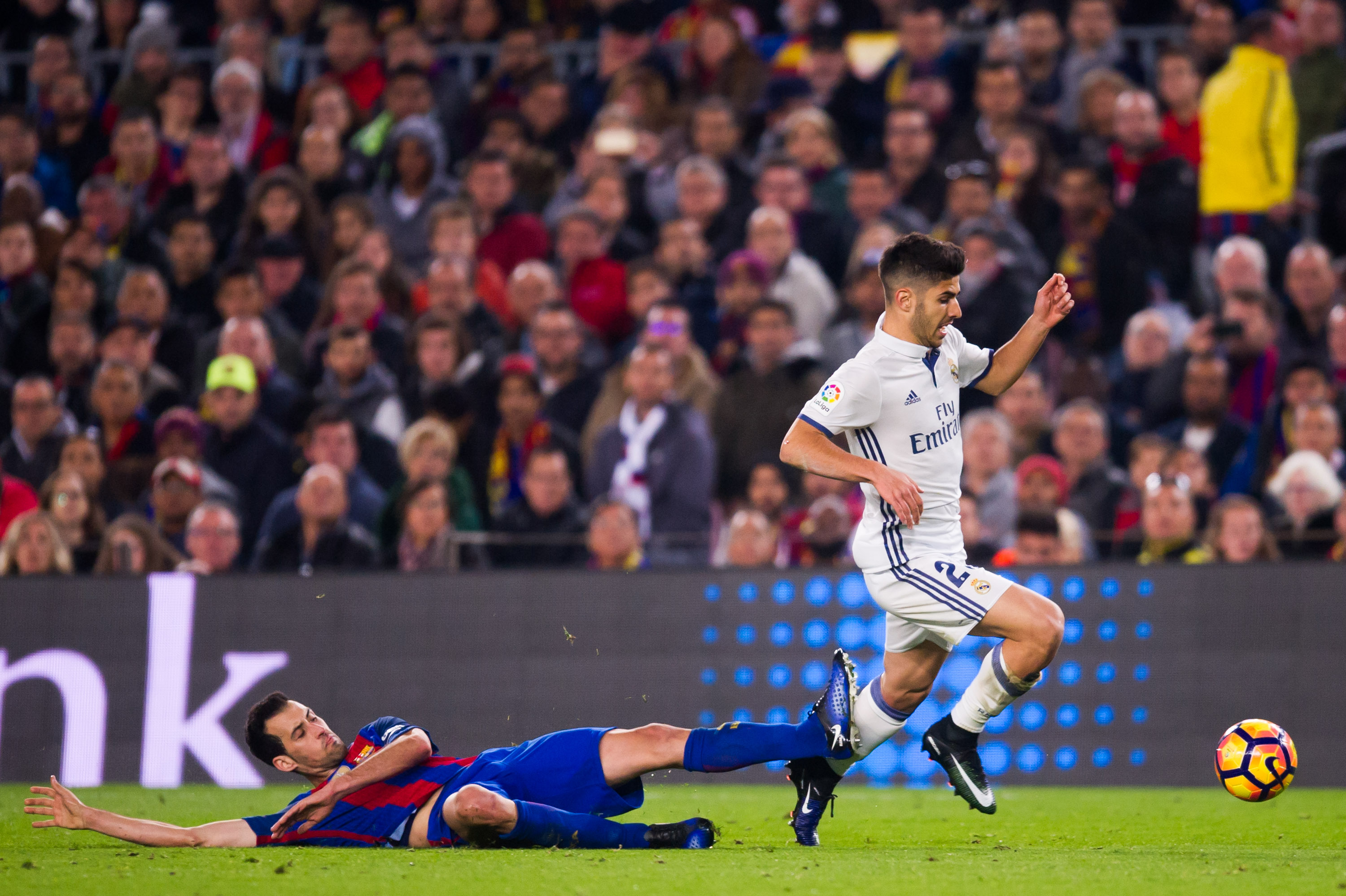 BARCELONA, SPAIN - DECEMBER 03:  Sergio Busquets (L) of FC Barcelona tackles Marco Asensio of Real Madrid CF during the La Liga match between FC Barcelona and Real Madrid CF at Camp Nou stadium on December 3, 2016 in Barcelona, Spain.  (Photo by Alex Caparros/Getty Images)