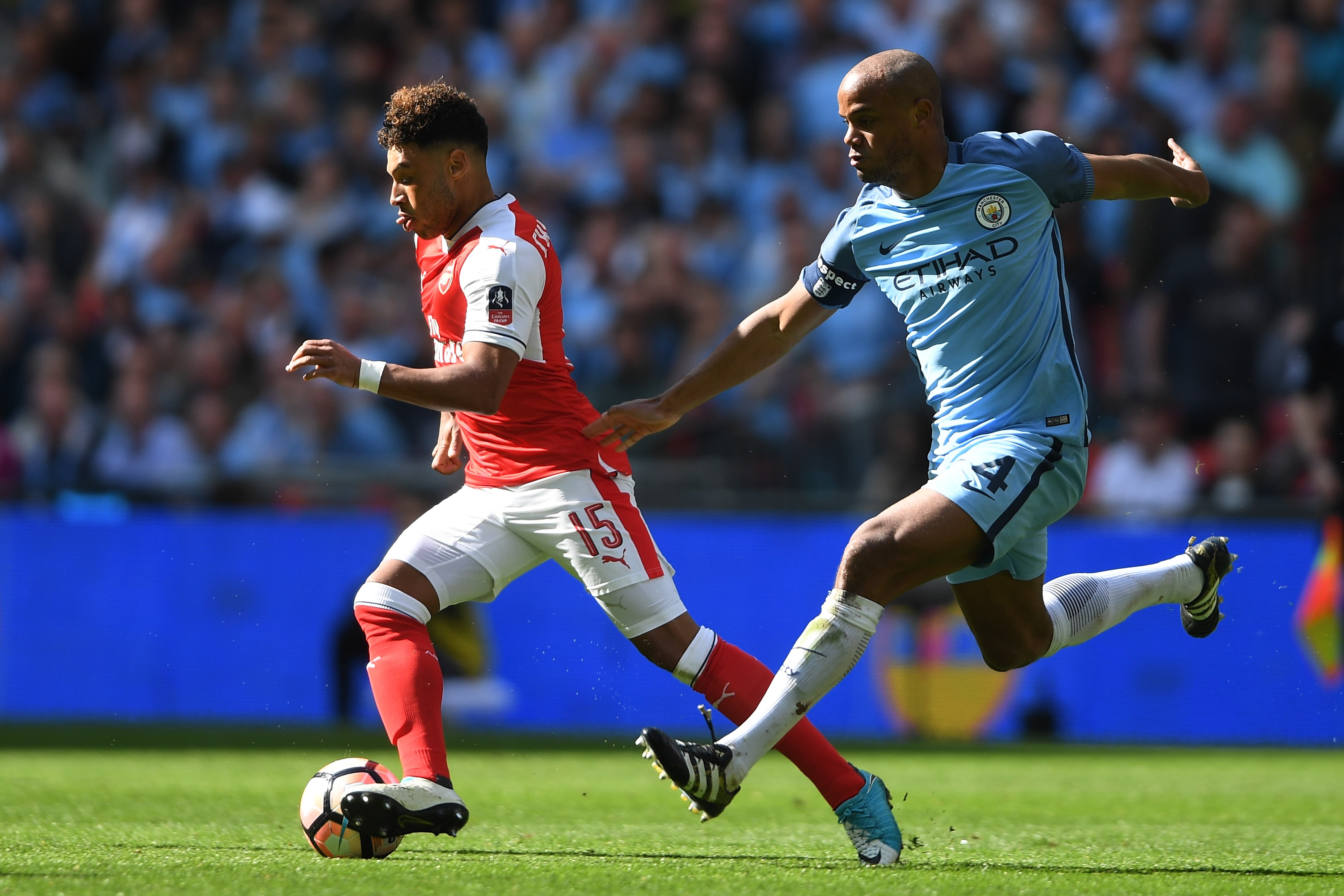 LONDON, ENGLAND - APRIL 23:  Alex Oxlade-Chamberlain of Arsenal and Vincent Kompany of Manchester City compete for the ball during the Emirates FA Cup Semi-Final match between Arsenal and Manchester City at Wembley Stadium on April 23, 2017 in London, England.  (Photo by Mike Hewitt/Getty Images,)