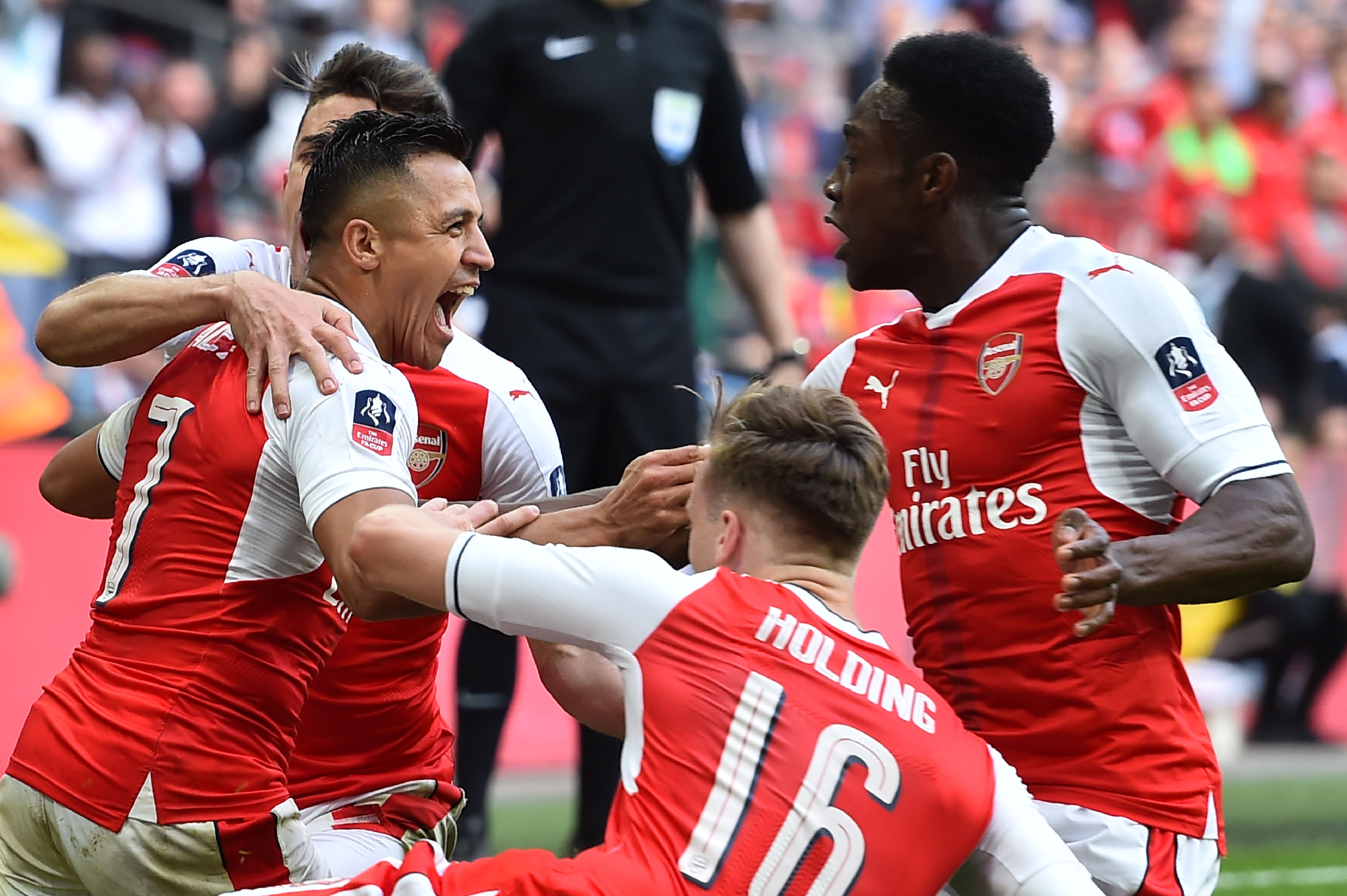 Arsenal's Chilean striker Alexis Sanchez (L) celebrates scoring the second goal with teammates during the FA Cup semi-final football match between Arsenal and Manchester City at Wembley stadium in London on April 23, 2017. / AFP PHOTO / Glyn KIRK / NOT FOR MARKETING OR ADVERTISING USE / RESTRICTED TO EDITORIAL USE
        (Photo credit should read GLYN KIRK/AFP/Getty Images)