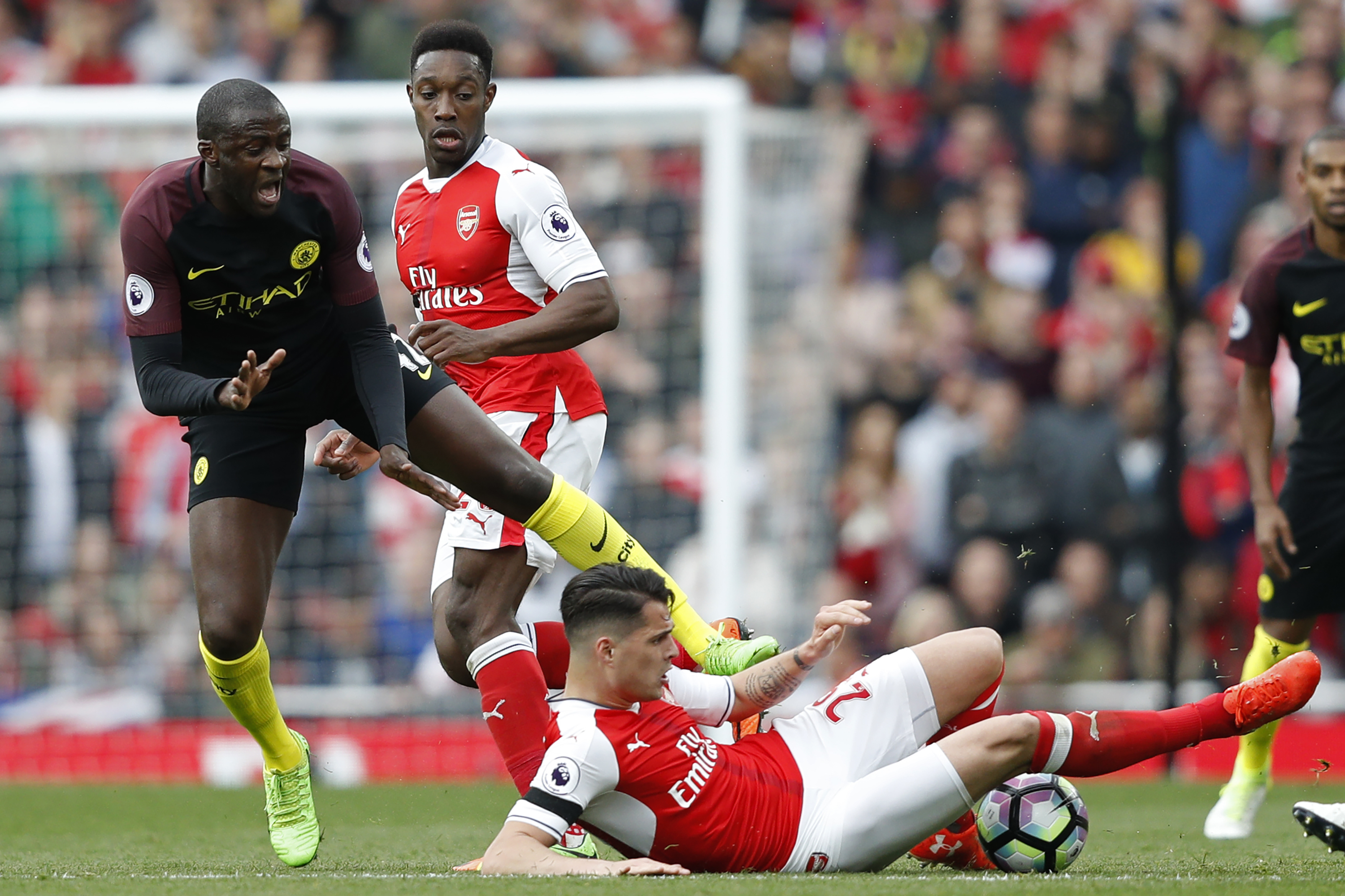 Arsenal's Swiss midfielder Granit Xhaka (R) tackles Manchester City's Ivorian midfielder Yaya Toure during the English Premier League football match between Arsenal and Manchester City at the Emirates Stadium in London on April 2, 2017.  / AFP PHOTO / Adrian DENNIS / RESTRICTED TO EDITORIAL USE. No use with unauthorized audio, video, data, fixture lists, club/league logos or 'live' services. Online in-match use limited to 75 images, no video emulation. No use in betting, games or single club/league/player publications.  /         (Photo credit should read ADRIAN DENNIS/AFP/Getty Images)
