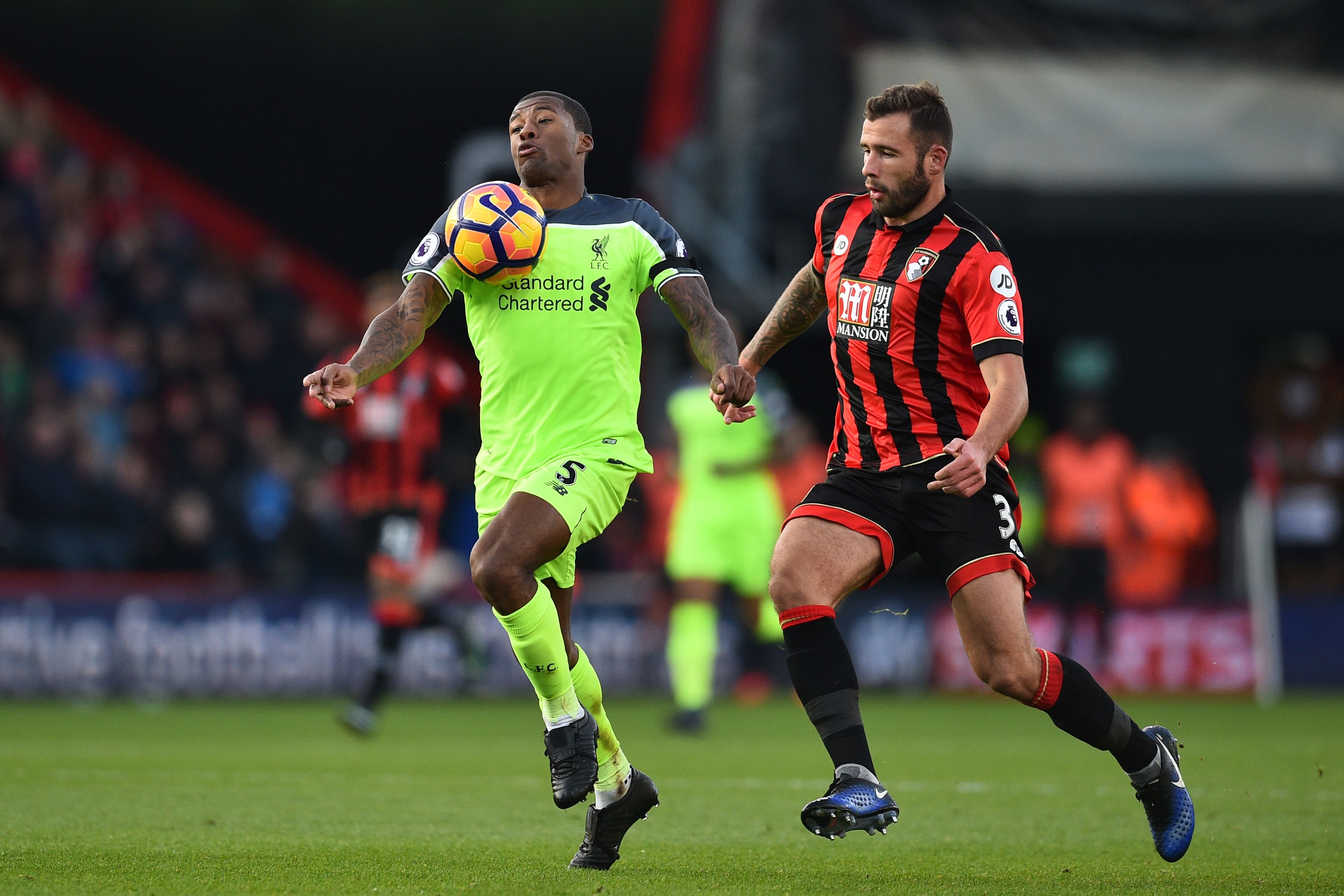 Liverpool's Dutch midfielder Georginio Wijnaldum vies with Bournemouth's English defender Steve Cook (R) during the English Premier League football match between Bournemouth and Liverpool at the Vitality Stadium in Bournemouth, southern England on December 4, 2016. / AFP / Glyn KIRK / RESTRICTED TO EDITORIAL USE. No use with unauthorized audio, video, data, fixture lists, club/league logos or 'live' services. Online in-match use limited to 75 images, no video emulation. No use in betting, games or single club/league/player publications.  /         (Photo credit should read GLYN KIRK/AFP/Getty Images)