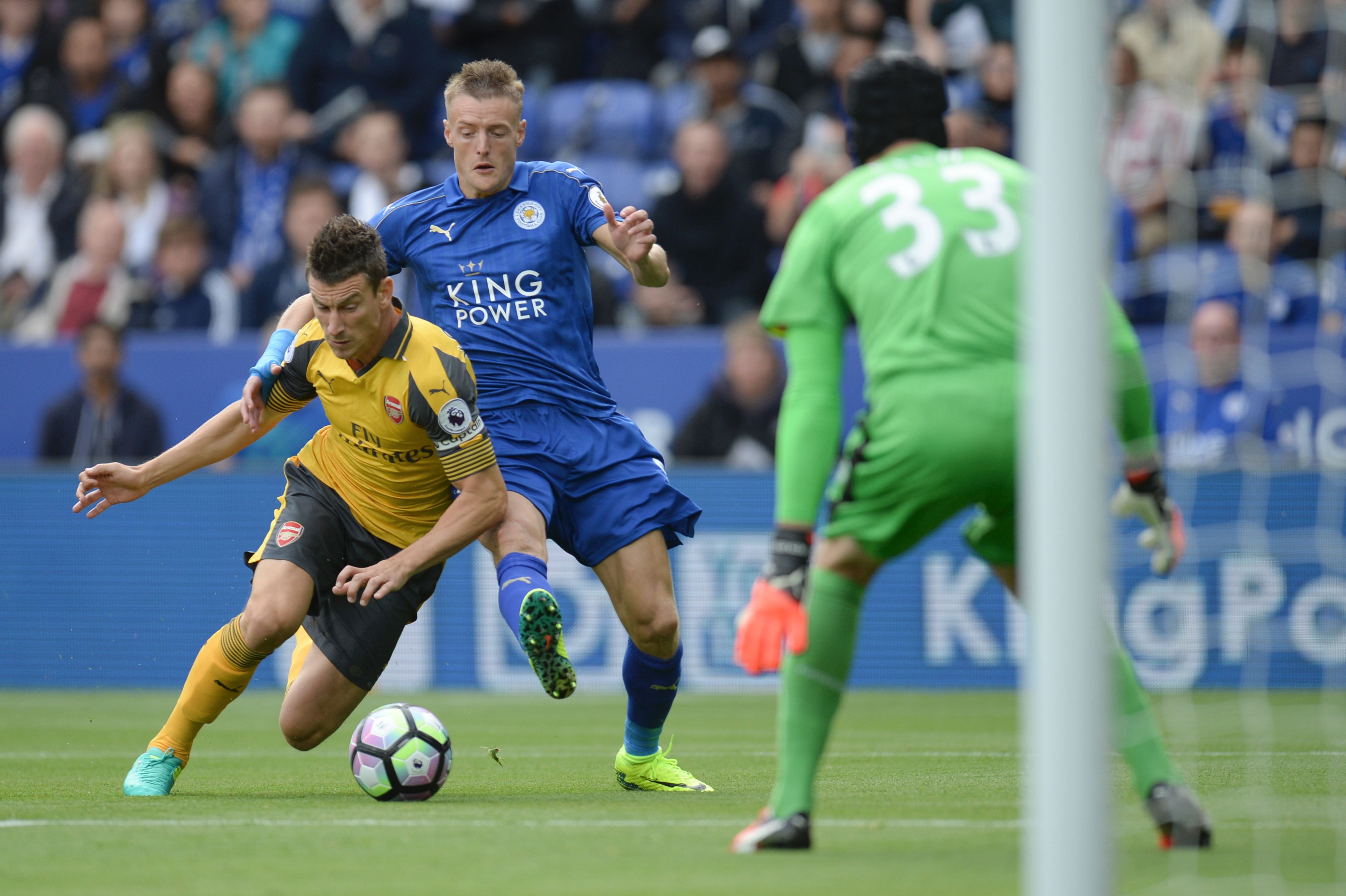Arsenal's French defender Laurent Koscielny (L) tackles Leicester City's English striker Jamie Vardy (C) in the area during the English Premier League football match between Leicester City and Arsenal at King Power Stadium in Leicester, central England on August 20, 2016. / AFP / OLI SCARFF / RESTRICTED TO EDITORIAL USE. No use with unauthorized audio, video, data, fixture lists, club/league logos or 'live' services. Online in-match use limited to 75 images, no video emulation. No use in betting, games or single club/league/player publications.  /         (Photo credit should read OLI SCARFF/AFP/Getty Images)