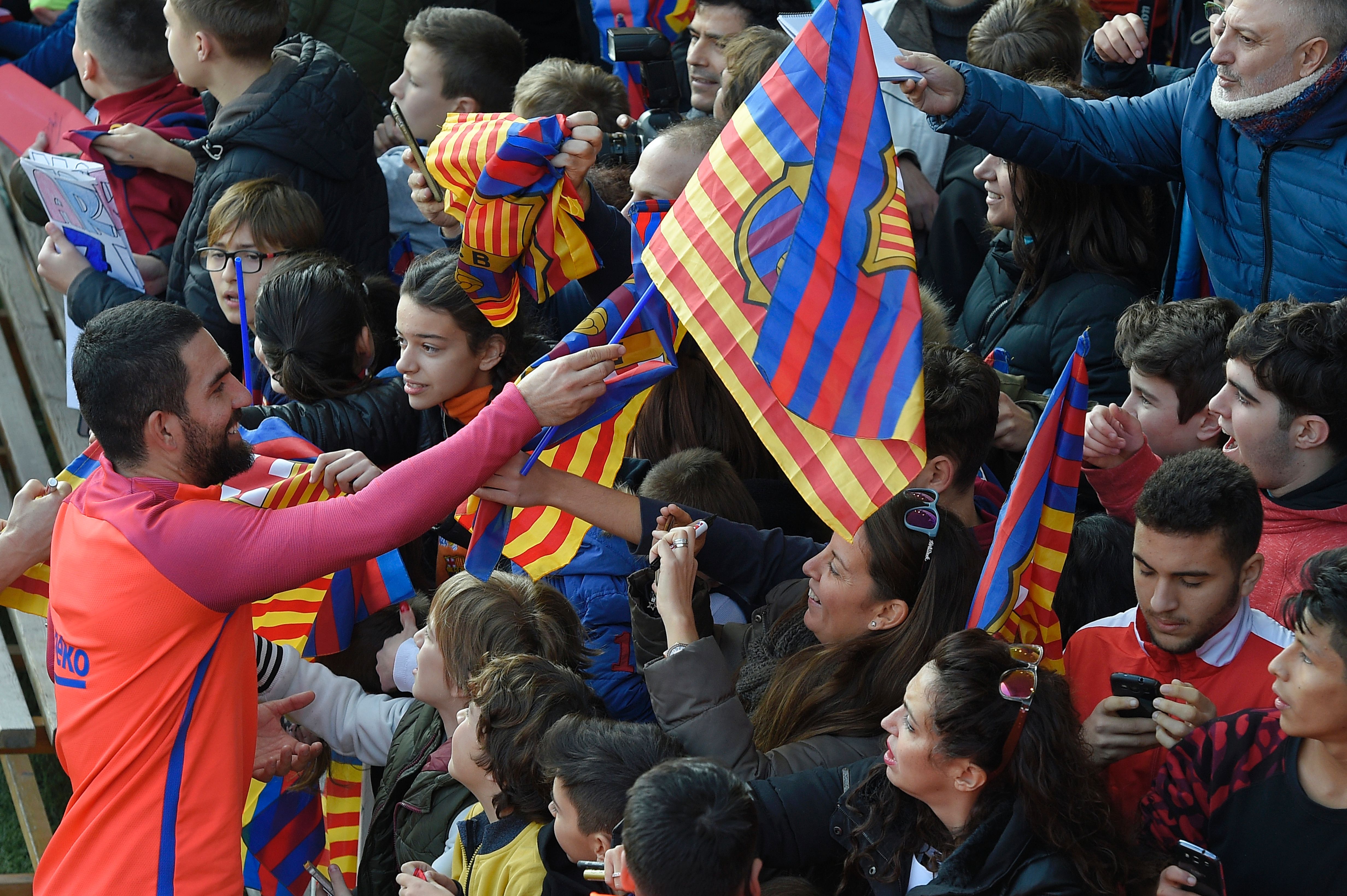 Barcelona's Turkish forward Arda Turan (L) signs autographs at the end of a training session at the Mini stadium in Barcelona on January 3, 2017.
 / AFP / LLUIS GENE        (Photo credit should read LLUIS GENE/AFP/Getty Images)