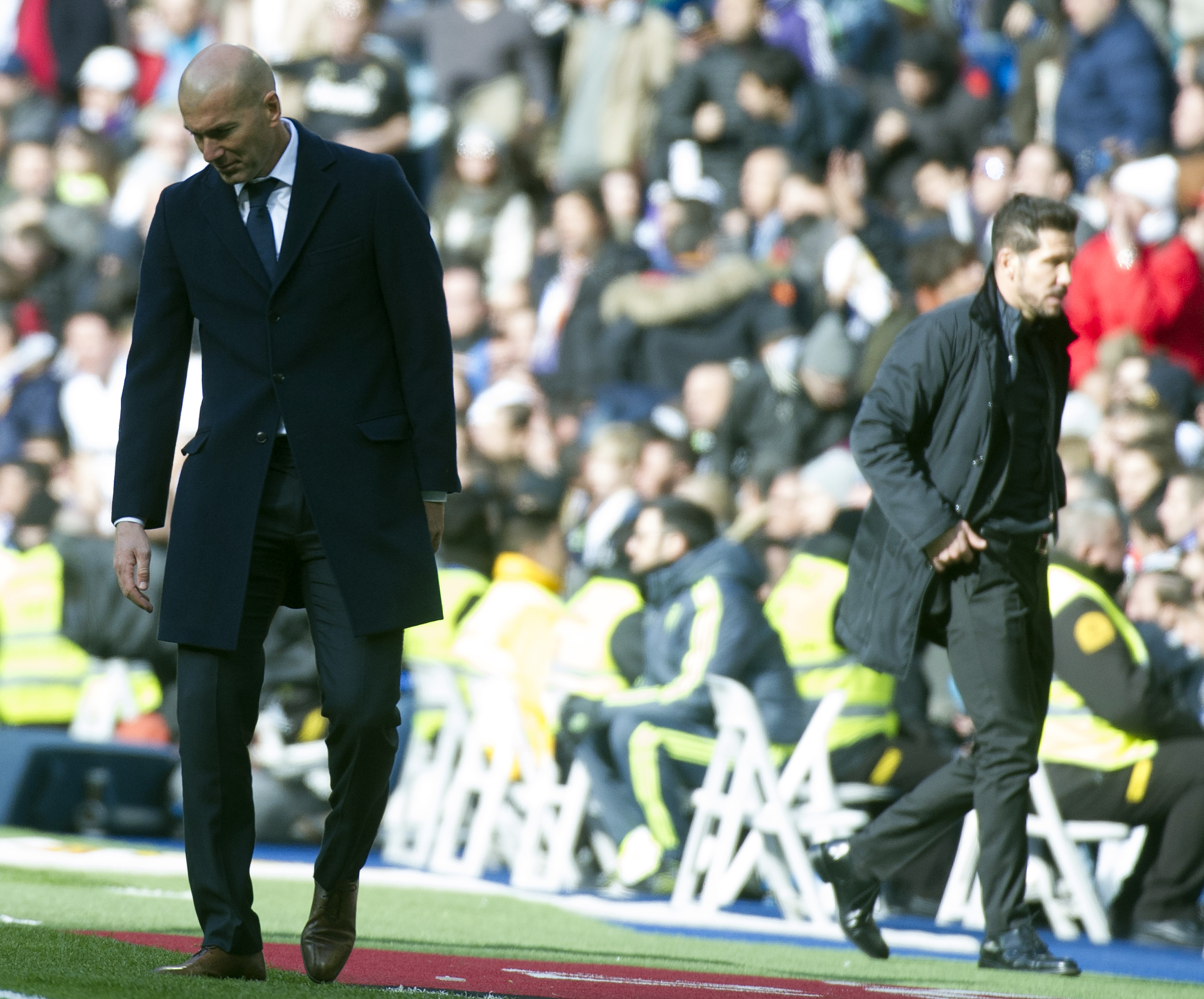 Real Madrid's French coach Zinedine Zidane (L) looks down next to Atletico Madrid's Argentinian coach Diego Simeone during the Spanish league football match Real Madrid CF vs Club Atletico de Madrid at the Santiago Bernabeu stadium in Madrid on February 27, 2016. / AFP / CURTO DE LA TORRE        (Photo credit should read CURTO DE LA TORRE/AFP/Getty Images)