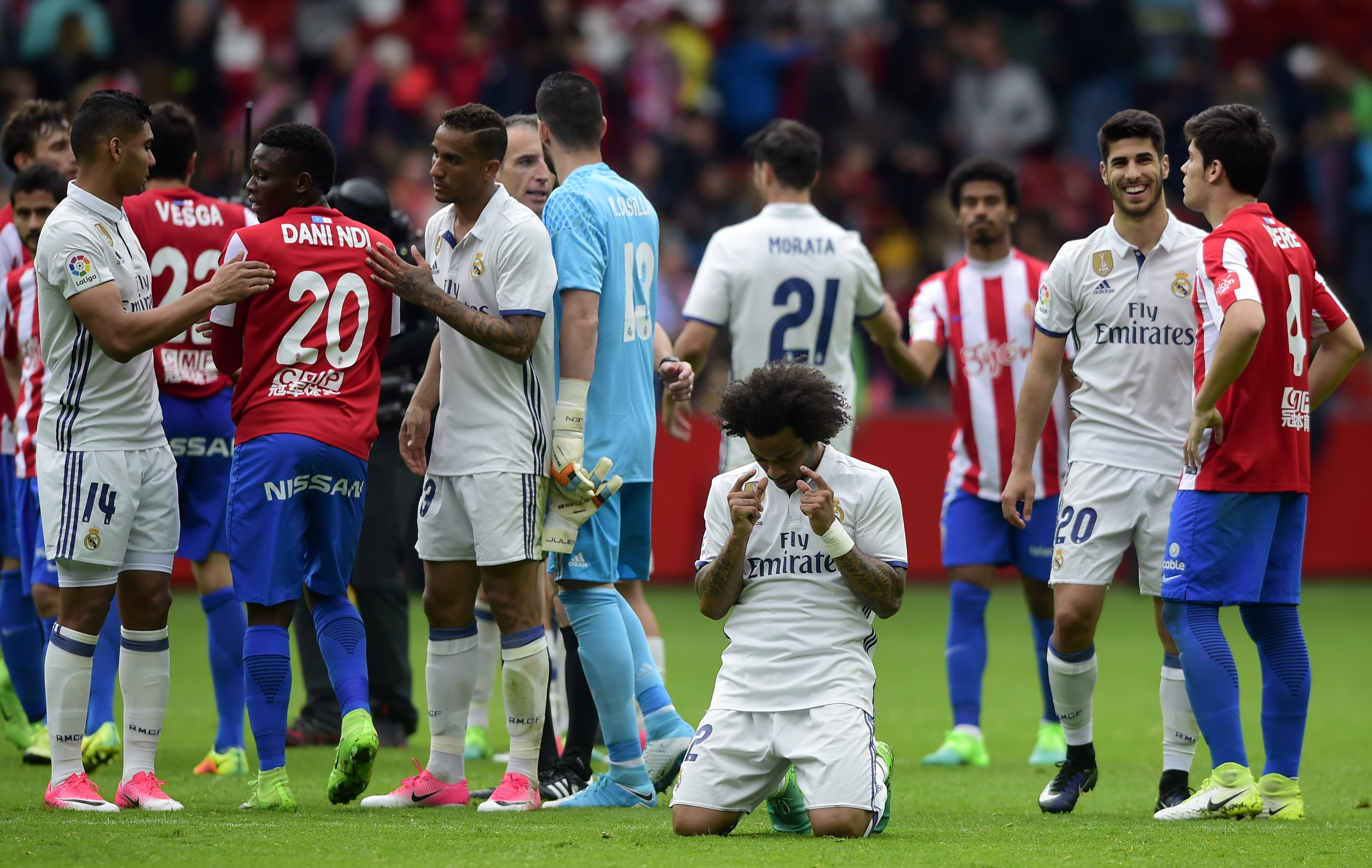 Real Madrid's Brazilian defender Marcelo (C) kneels at the end of the Spanish league football match Real Sporting de Gijon vs Real Madrid CF at El Molinon stadium in Gijon on April 15, 2017. / AFP PHOTO / MIGUEL RIOPA        (Photo credit should read MIGUEL RIOPA/AFP/Getty Images)