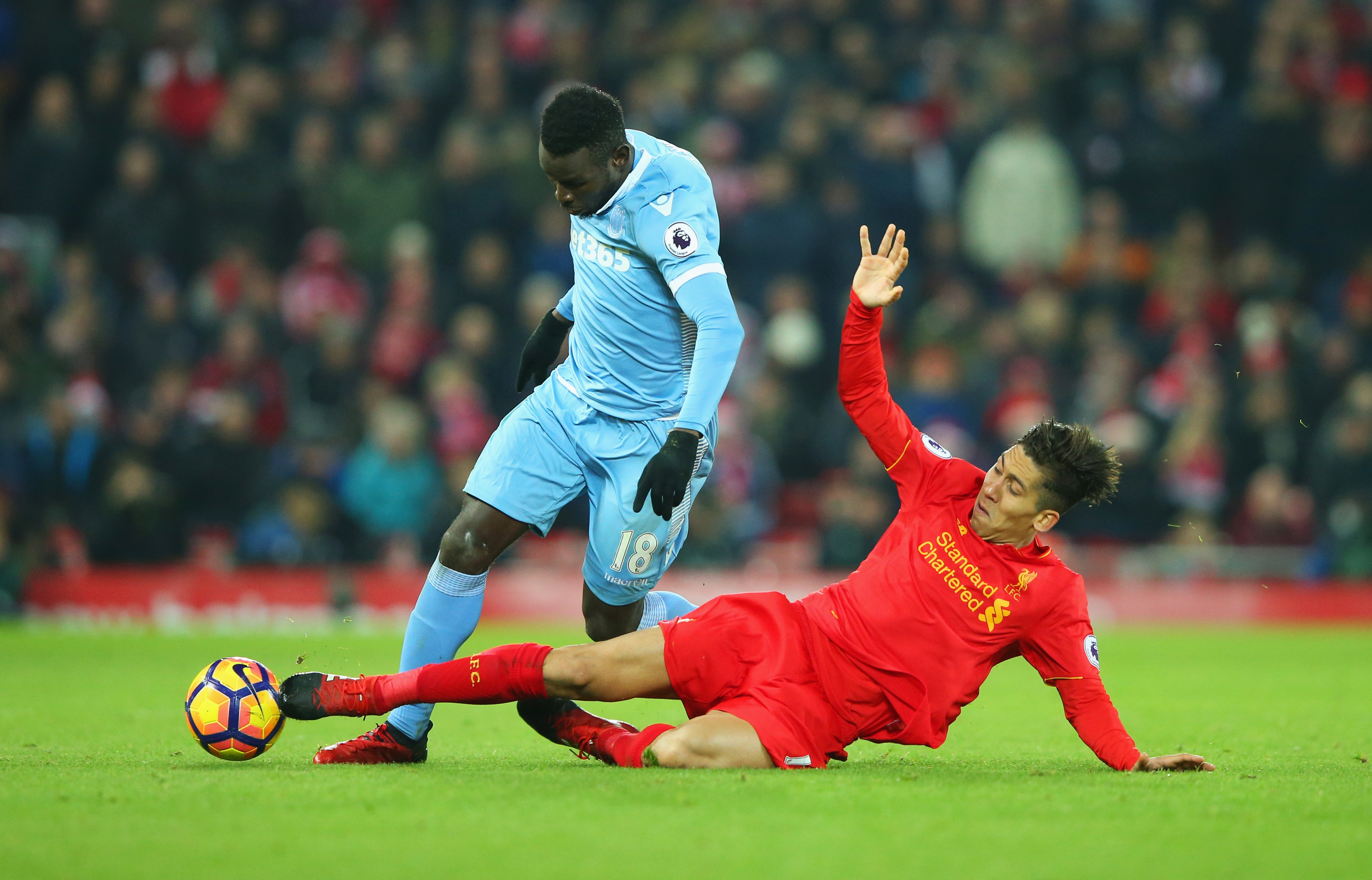 LIVERPOOL, ENGLAND - DECEMBER 27:  Mame Biram Diouf of Stoke City is challenged by Roberto Firmino of Liverpool during the Premier League match between Liverpool and Stoke City at Anfield on December 27, 2016 in Liverpool, England.  (Photo by Alex Livesey/Getty Images)