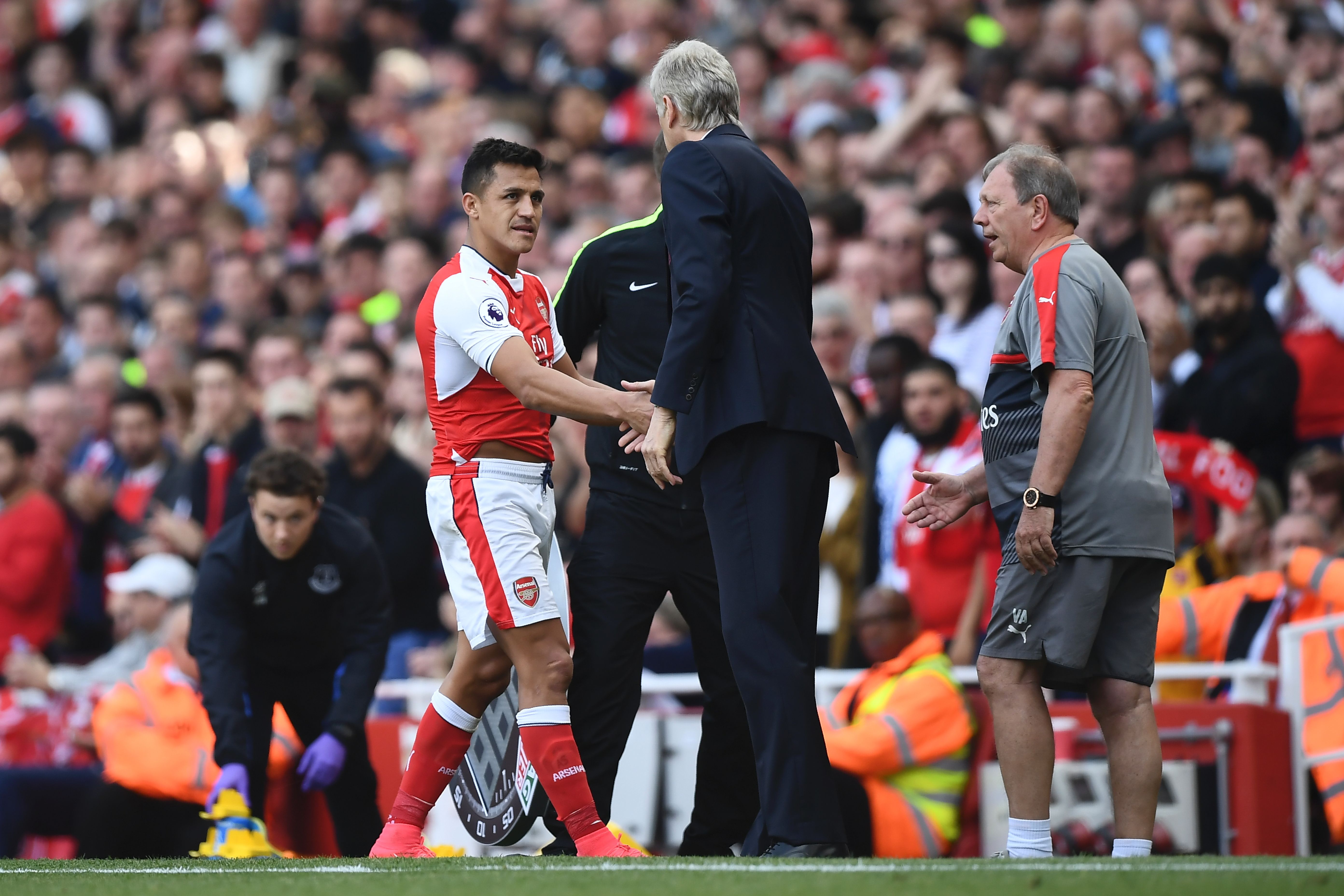 Arsenal's Chilean striker Alexis Sanchez (L) shakes hands with Arsenal's French manager Arsene Wenger (R) as he goes off substituted during the English Premier League football match between Arsenal and Everton at the Emirates Stadium in London on May 21, 2017.  / AFP PHOTO / Justin TALLIS / RESTRICTED TO EDITORIAL USE. No use with unauthorized audio, video, data, fixture lists, club/league logos or 'live' services. Online in-match use limited to 75 images, no video emulation. No use in betting, games or single club/league/player publications.  /         (Photo credit should read JUSTIN TALLIS/AFP/Getty Images)