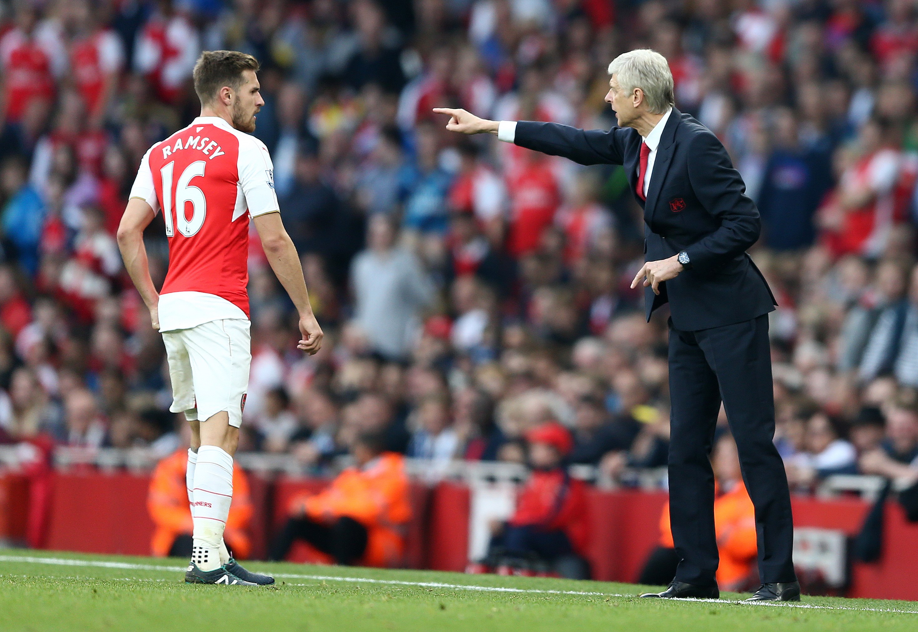 Arsenal's French manager Arsene Wenger (R) gestures towards Arsenal's Welsh midfielder Aaron Ramsey during the English Premier League football match between Arsenal and Manchester United at the Emirates Stadium in London on October 4, 2015.    AFP PHOTO / JUSTIN TALLIS

RESTRICTED TO EDITORIAL USE. No use with unauthorised audio, video, data, fixture lists, club/league logos or "live" services. Online in-match use limited to 45 images, no video emulation. No use in betting, games or single club/league/player publications.        (Photo credit should read JUSTIN TALLIS/AFP/Getty Images)