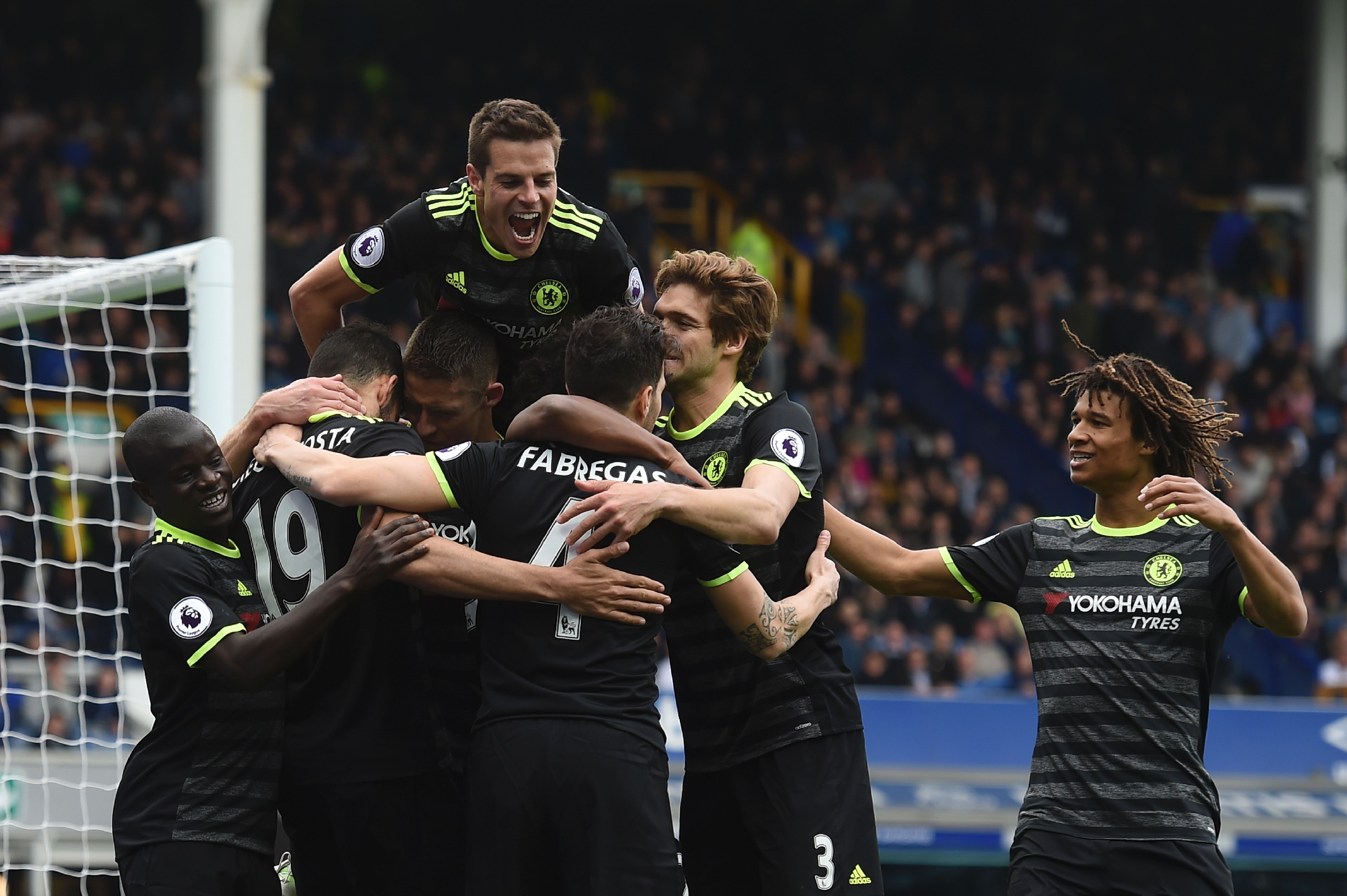 Chelsea's Spanish defender Cesar Azpilicueta (top C) jumps onto the celebration after Chelsea's Brazilian midfielder Willian scored their third goal during the English Premier League football match between Everton and Chelsea at Goodison Park in Liverpool, north west England on April 30, 2017. / AFP PHOTO / PAUL ELLIS / RESTRICTED TO EDITORIAL USE. No use with unauthorized audio, video, data, fixture lists, club/league logos or 'live' services. Online in-match use limited to 75 images, no video emulation. No use in betting, games or single club/league/player publications.  /         (Photo credit should read PAUL ELLIS/AFP/Getty Images)
