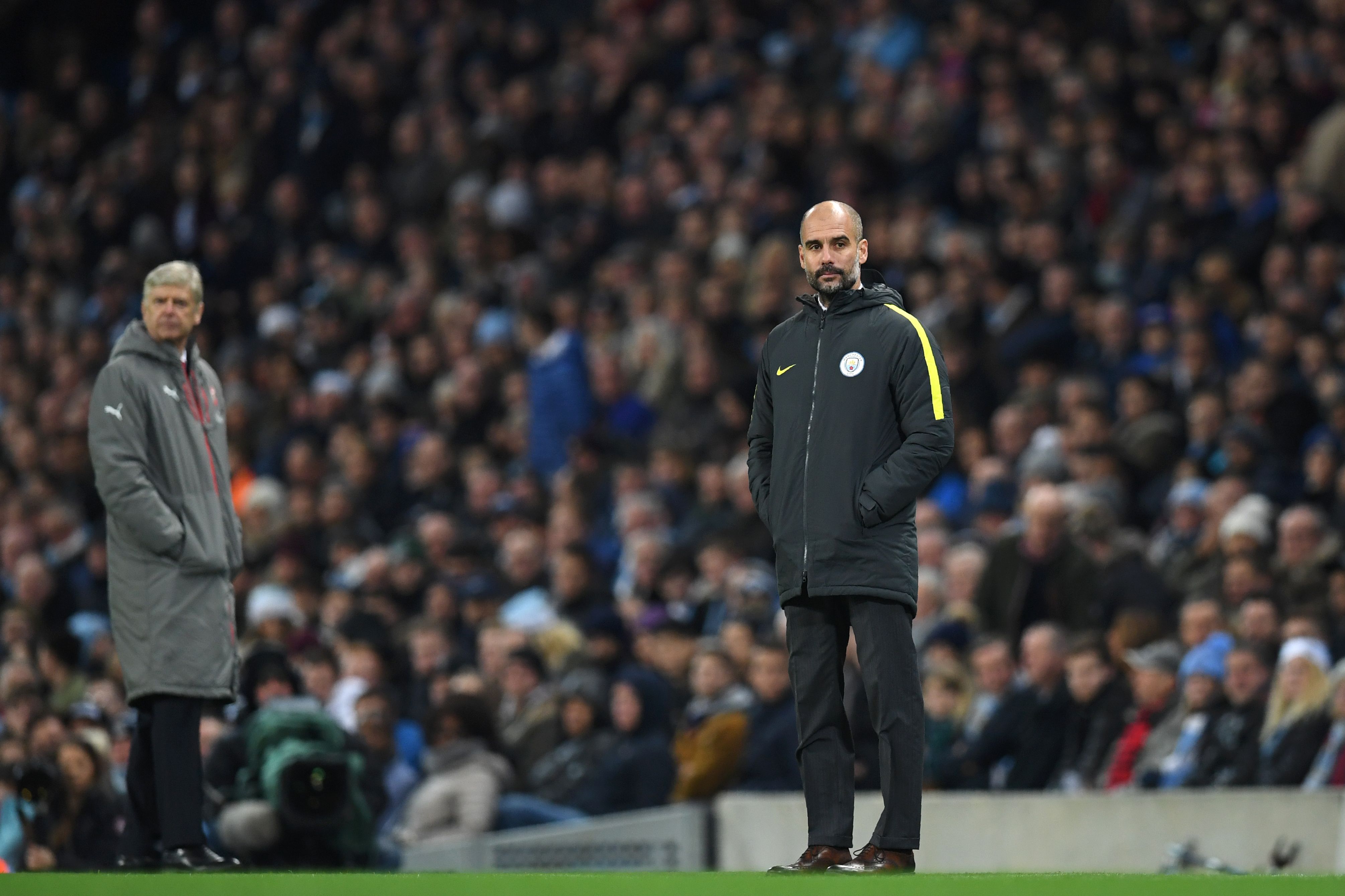 Arsenal's French manager Arsene Wenger (L) and Manchester City's Spanish manager Pep Guardiola watch the game from the touchline during the English Premier League football match between Manchester City and Arsenal at the Etihad Stadium in Manchester, north west England, on December 18, 2016. / AFP / Paul ELLIS / RESTRICTED TO EDITORIAL USE. No use with unauthorized audio, video, data, fixture lists, club/league logos or 'live' services. Online in-match use limited to 75 images, no video emulation. No use in betting, games or single club/league/player publications.  /         (Photo credit should read PAUL ELLIS/AFP/Getty Images)