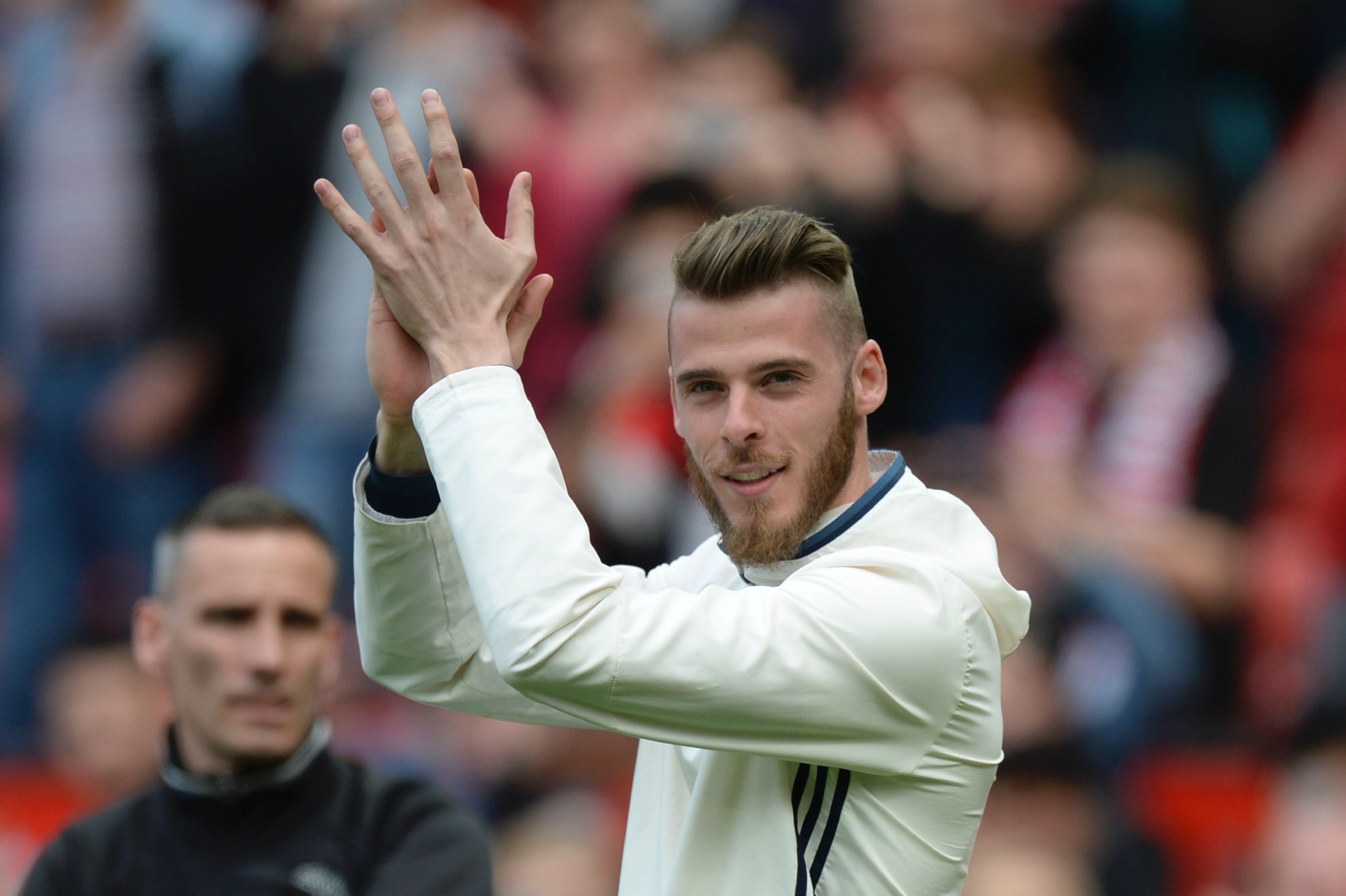 de Manchester United's Spanish goalkeeper David de Gea walks on the pitch to applaud the fans at the end of the English Premier League football match between Manchester United and Cyrstal Palace at Old Trafford in Manchester, north west England, on May 21, 2017. / AFP PHOTO / Oli SCARFF / RESTRICTED TO EDITORIAL USE. No use with unauthorized audio, video, data, fixture lists, club/league logos or 'live' services. Online in-match use limited to 75 images, no video emulation. No use in betting, games or single club/league/player publications.  /         (Photo credit should read OLI SCARFF/AFP/Getty Images)