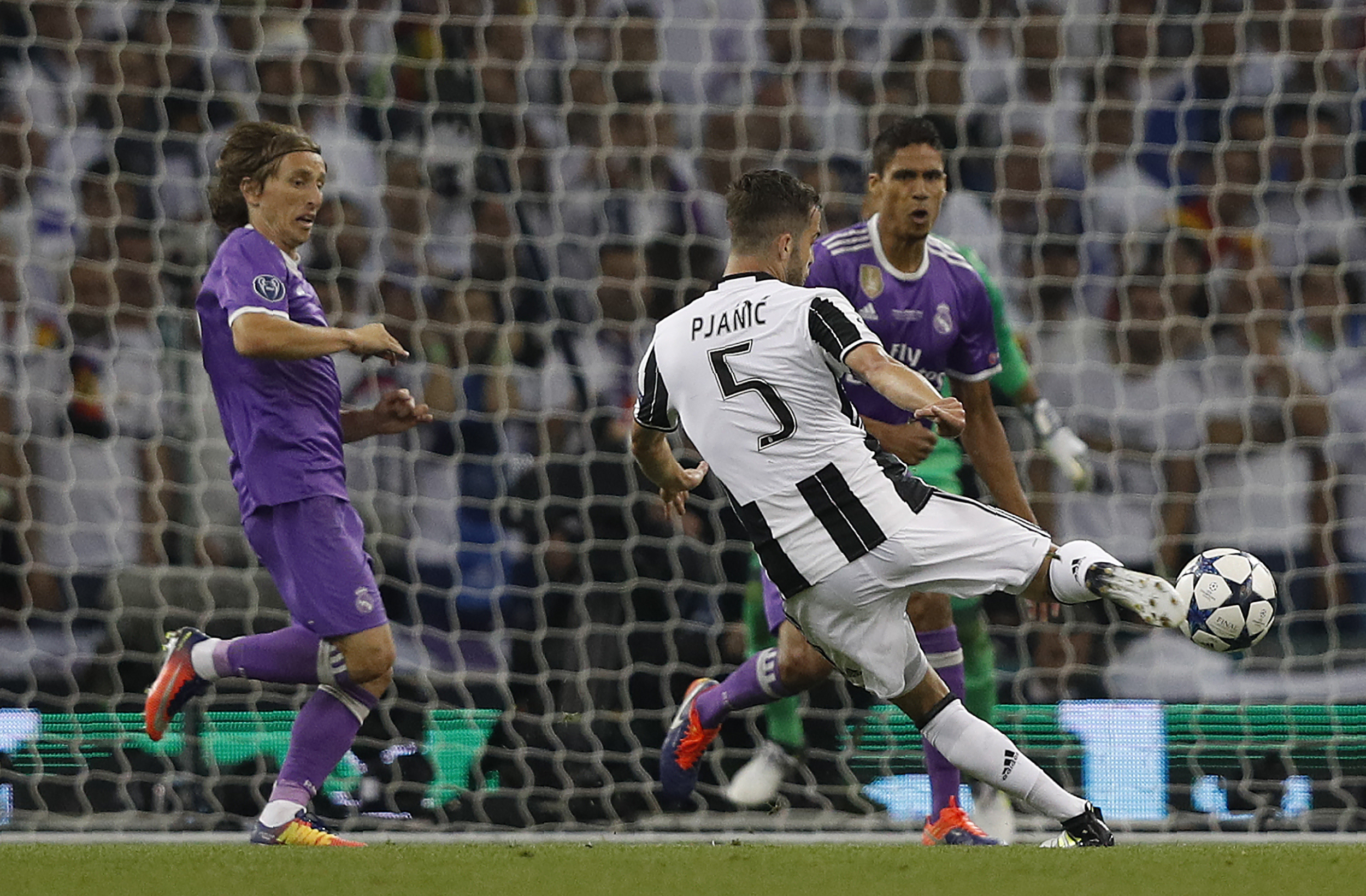 Juventus' Bosnian midfielder Miralem Pjanic (R) has a shot on goal during the UEFA Champions League final football match between Juventus and Real Madrid at The Principality Stadium in Cardiff, south Wales, on June 3, 2017. / AFP PHOTO / Adrian DENNIS        (Photo credit should read ADRIAN DENNIS/AFP/Getty Images)