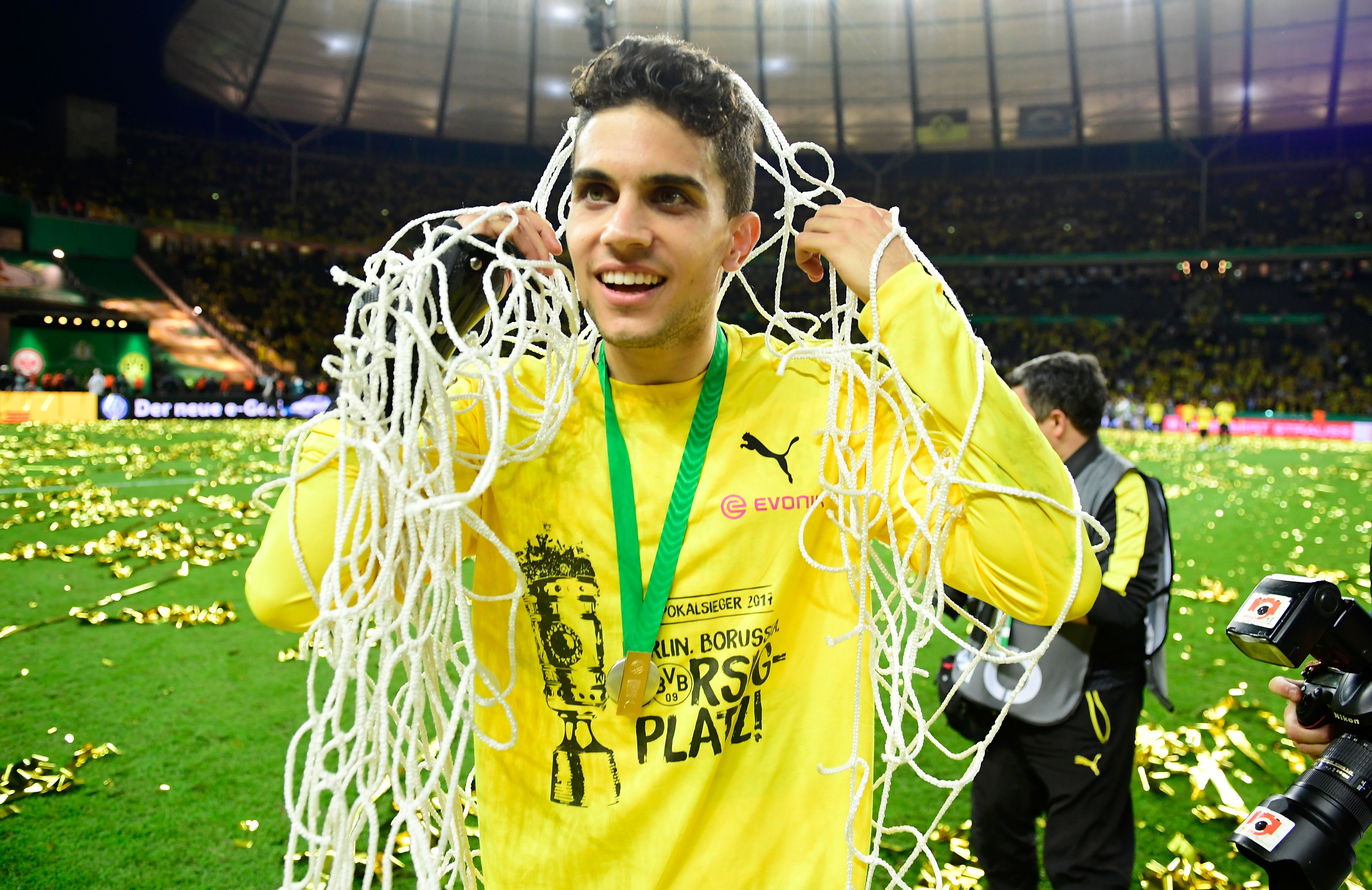 Dortmund's Spanish defender Marc Bartra holds the net after victory during the German Cup (DFB Pokal) final football match Eintracht Frankfurt v BVB Borussia Dortmund at the Olympic stadium in Berlin on May 27, 2017. / AFP PHOTO / Tobias SCHWARZ / RESTRICTIONS: ACCORDING TO DFB RULES IMAGE SEQUENCES TO SIMULATE VIDEO IS NOT ALLOWED DURING MATCH TIME. MOBILE (MMS) USE IS NOT ALLOWED DURING AND FOR FURTHER TWO HOURS AFTER THE MATCH. == RESTRICTED TO EDITORIAL USE == FOR MORE INFORMATION CONTACT DFB DIRECTLY AT +49 69 67880

 /         (Photo credit should read TOBIAS SCHWARZ/AFP/Getty Images)