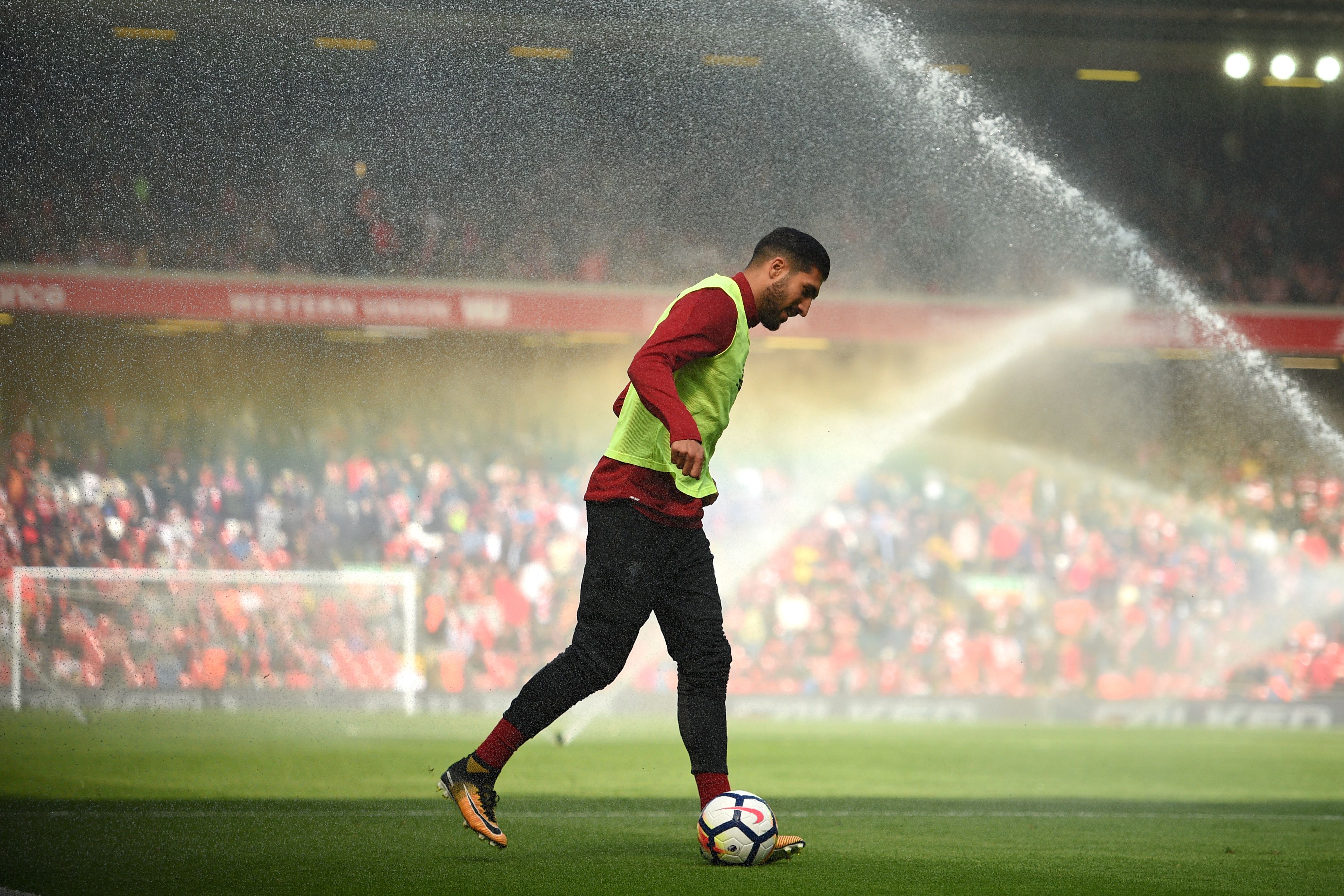 Liverpool's German midfielder Emre Can warms up as the pitch is watered at half time in the English Premier League football match between Liverpool and Crystal Palace at Anfield in Liverpool, north west England on August 19, 2017. / AFP PHOTO / Oli SCARFF / RESTRICTED TO EDITORIAL USE. No use with unauthorized audio, video, data, fixture lists, club/league logos or 'live' services. Online in-match use limited to 75 images, no video emulation. No use in betting, games or single club/league/player publications.  /         (Photo credit should read OLI SCARFF/AFP/Getty Images)