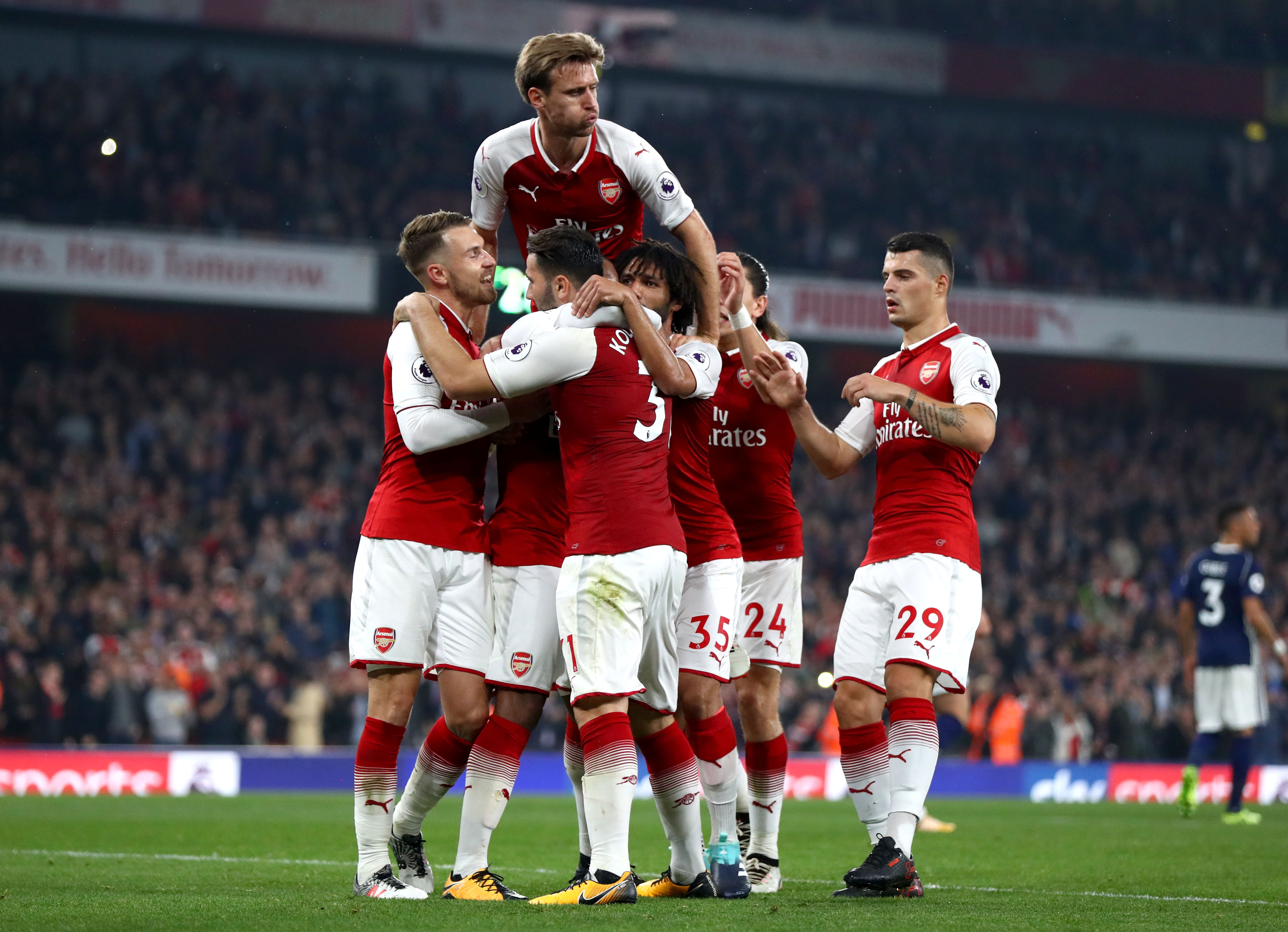 LONDON, ENGLAND - SEPTEMBER 25:  Alexandre Lacazette of Arsenal (obscured) celebrates with team mates as he scores their second goal from a penalty during the Premier League match between Arsenal and West Bromwich Albion at Emirates Stadium on September 25, 2017 in London, England.  (Photo by Michael Steele/Getty Images)