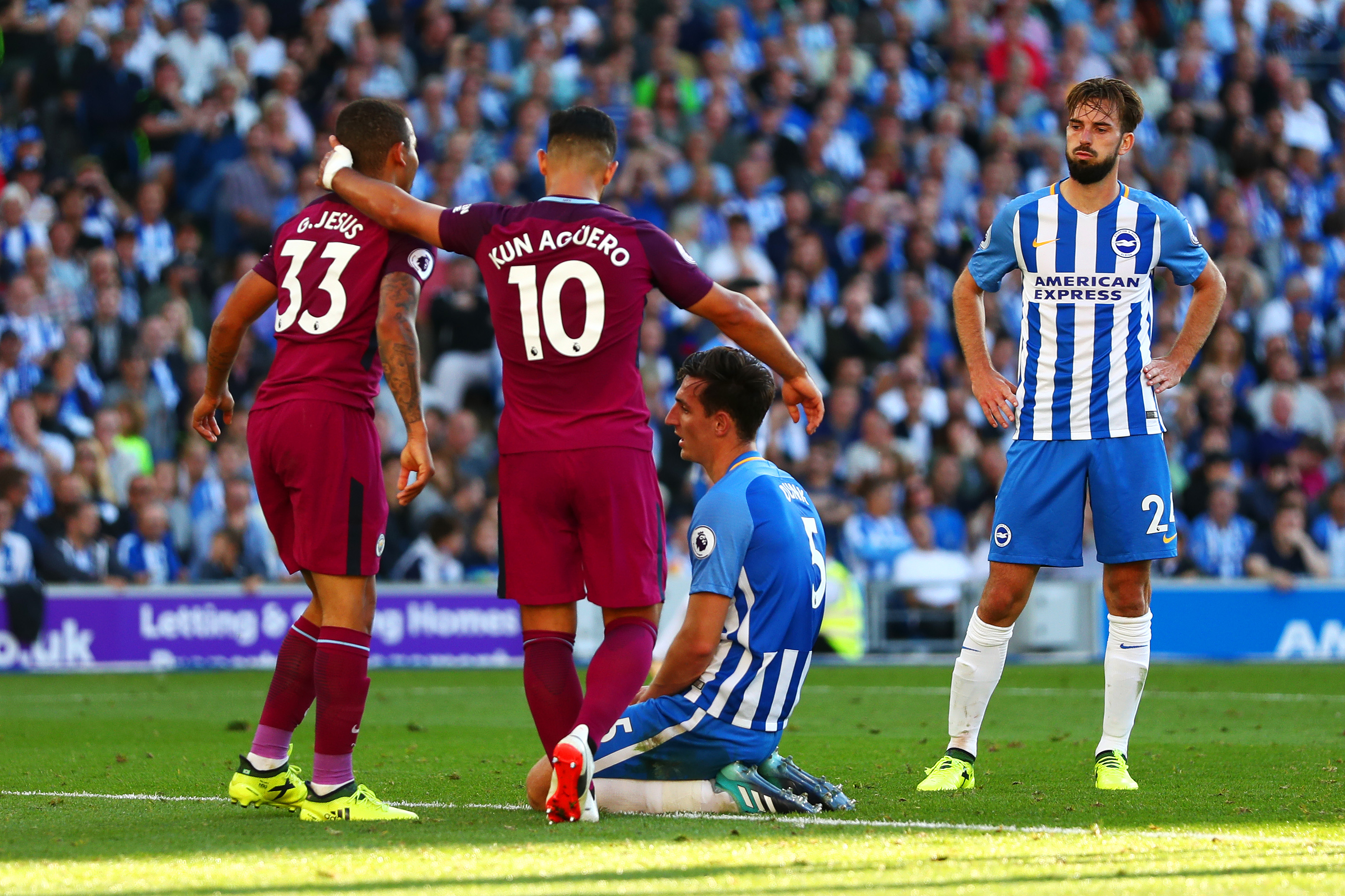 BRIGHTON, ENGLAND - AUGUST 12:  Lewis Dunk of Brighton and Hove Albion shows his dejection after scoring an own goal as Sergio Aguero and Gabriel Jesus of Manchester City celebrate during the Premier League match between Brighton and Hove Albion and Manchester City at Amex Stadium on August 12, 2017 in Brighton, England.  (Photo by Dan Istitene/Getty Images)