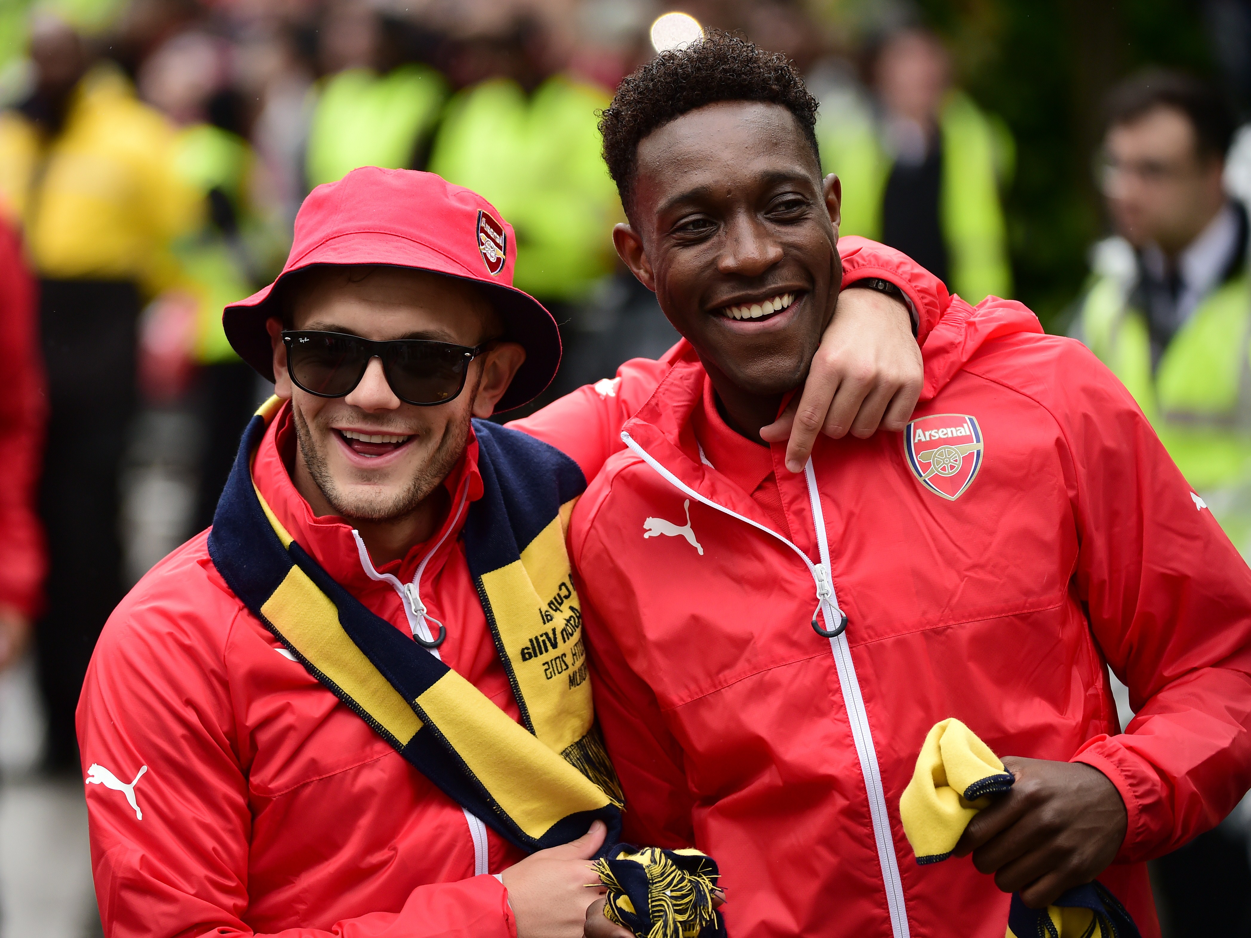 Arsenal's English midfielder Jack Wilshere and Arsenal's English striker Danny Welbeck react during the Arsenal victory parade in London on May 31, 2015, following their win in the English FA Cup final football match on May 30, 2014 against Aston Villa. Arsene Wenger's side made history at Wembley with a 4-0 rout of Aston Villa that underlined their renaissance in the second half of the campaign and served as a warning to English champions Chelsea.     AFP PHOTO / LEON NEAL        (Photo credit should read LEON NEAL/AFP/Getty Images)