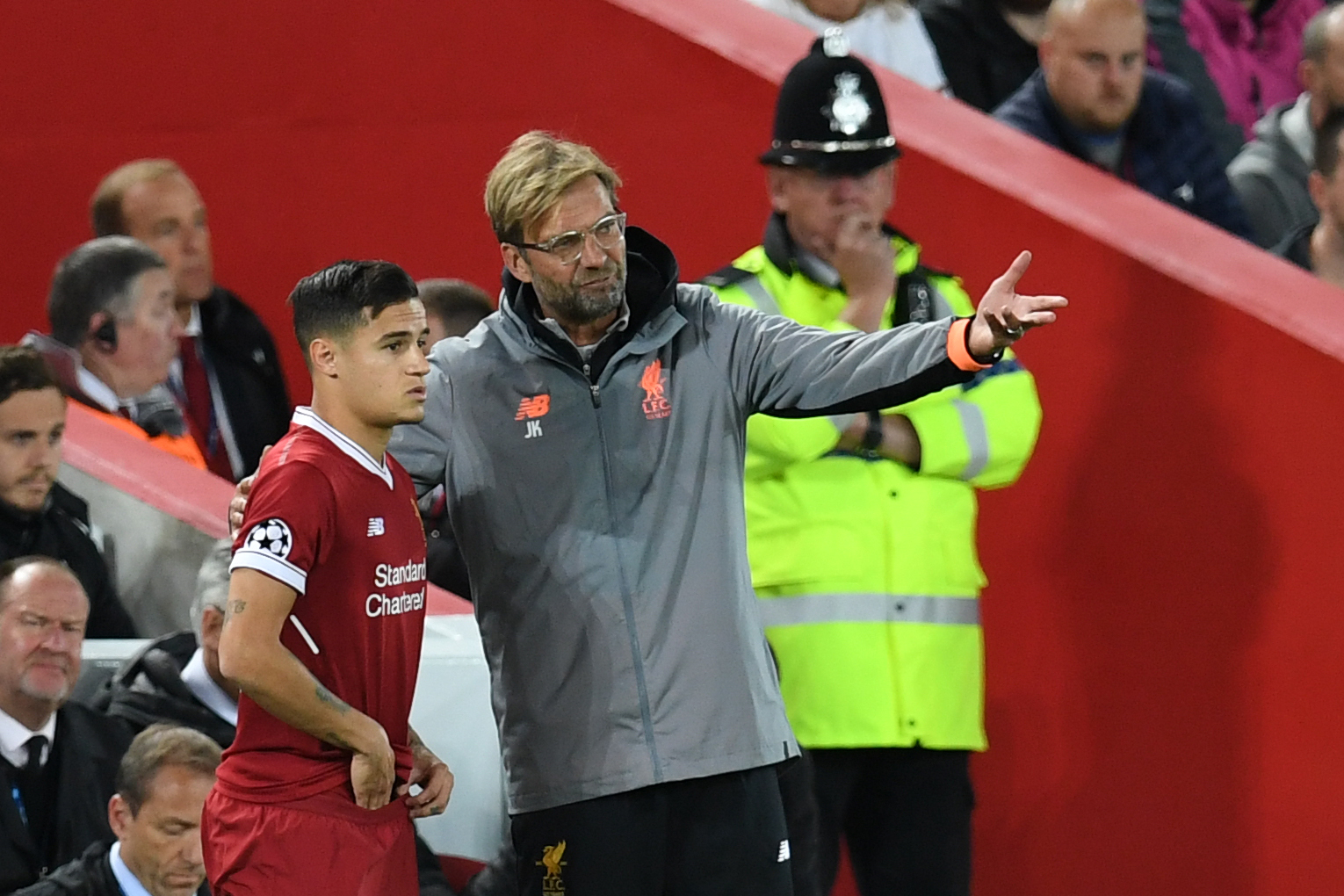 Liverpool's German manager Jurgen Klopp (C) speaks to Liverpool's Brazilian midfielder Philippe Coutinho as he prepares to play during the UEFA Champions League Group E football match between Liverpool and Sevilla at Anfield in Liverpool, north-west England on September 13, 2017. / AFP PHOTO / Paul ELLIS        (Photo credit should read PAUL ELLIS/AFP/Getty Images)