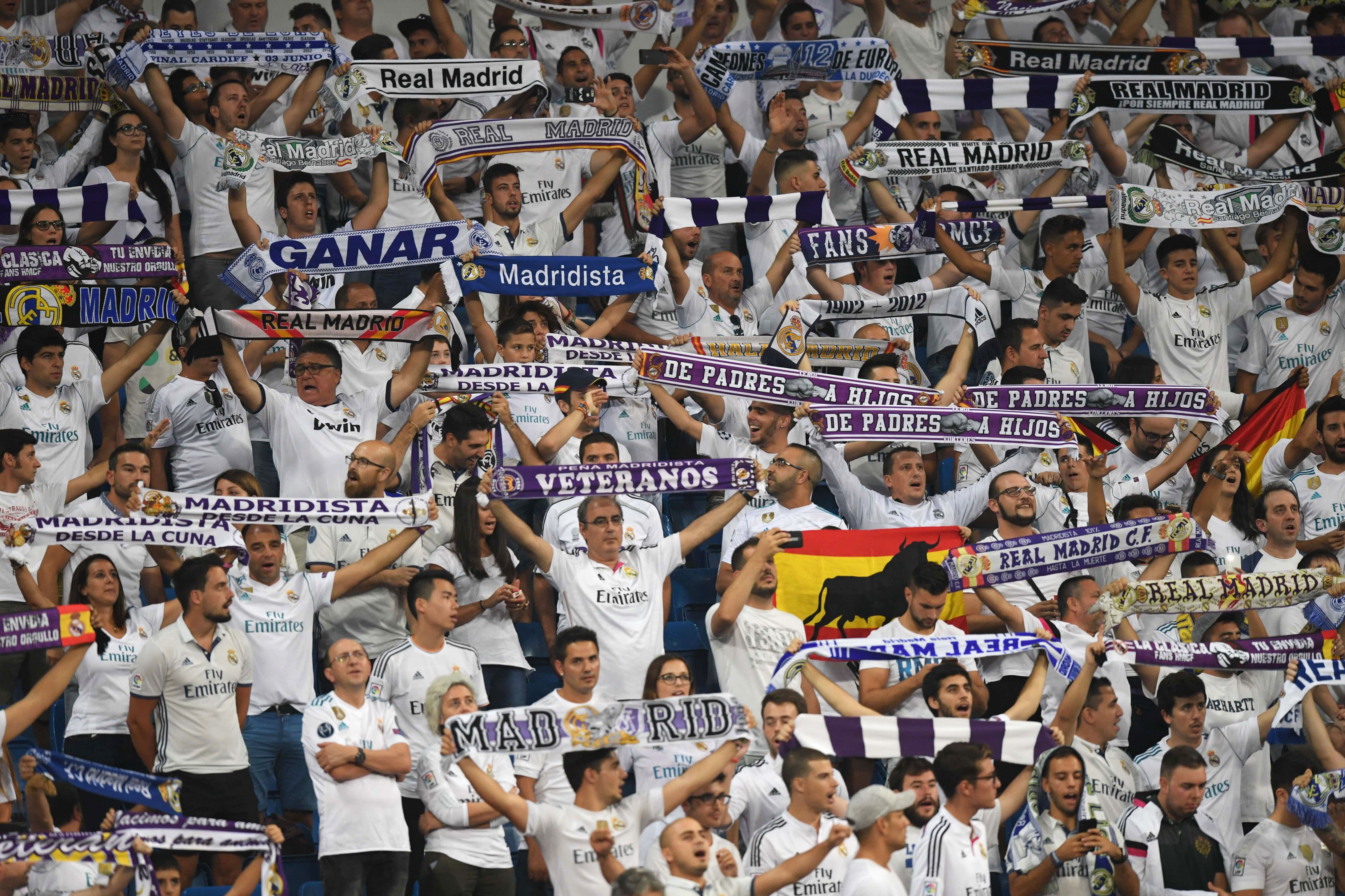 Real Madrid's fans brandish their scarfs before the UEFA Champions League football match Real Madrid CF vs APOEL FC at the Santiago Bernabeu stadium in Madrid on September 13, 2017. / AFP PHOTO / GABRIEL BOUYS        (Photo credit should read GABRIEL BOUYS/AFP/Getty Images)