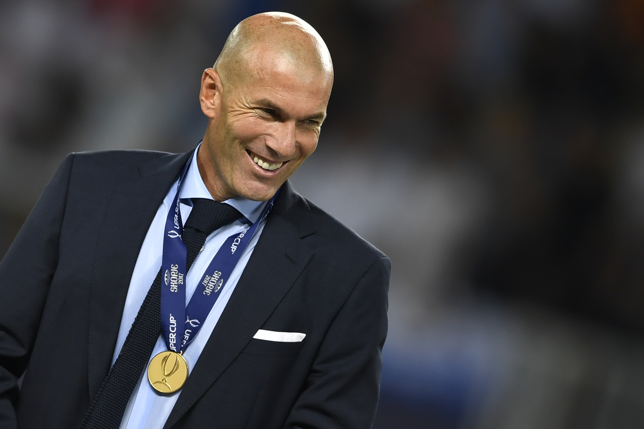 Real Madrid's French coach Zinedine Zidane smiles with his medal after winning the UEFA Super Cup football match between Real Madrid and Manchester United on August 8, 2017, at the Philip II Arena in Skopje. / AFP PHOTO / Dimitar DILKOFF        (Photo credit should read DIMITAR DILKOFF/AFP/Getty Images)