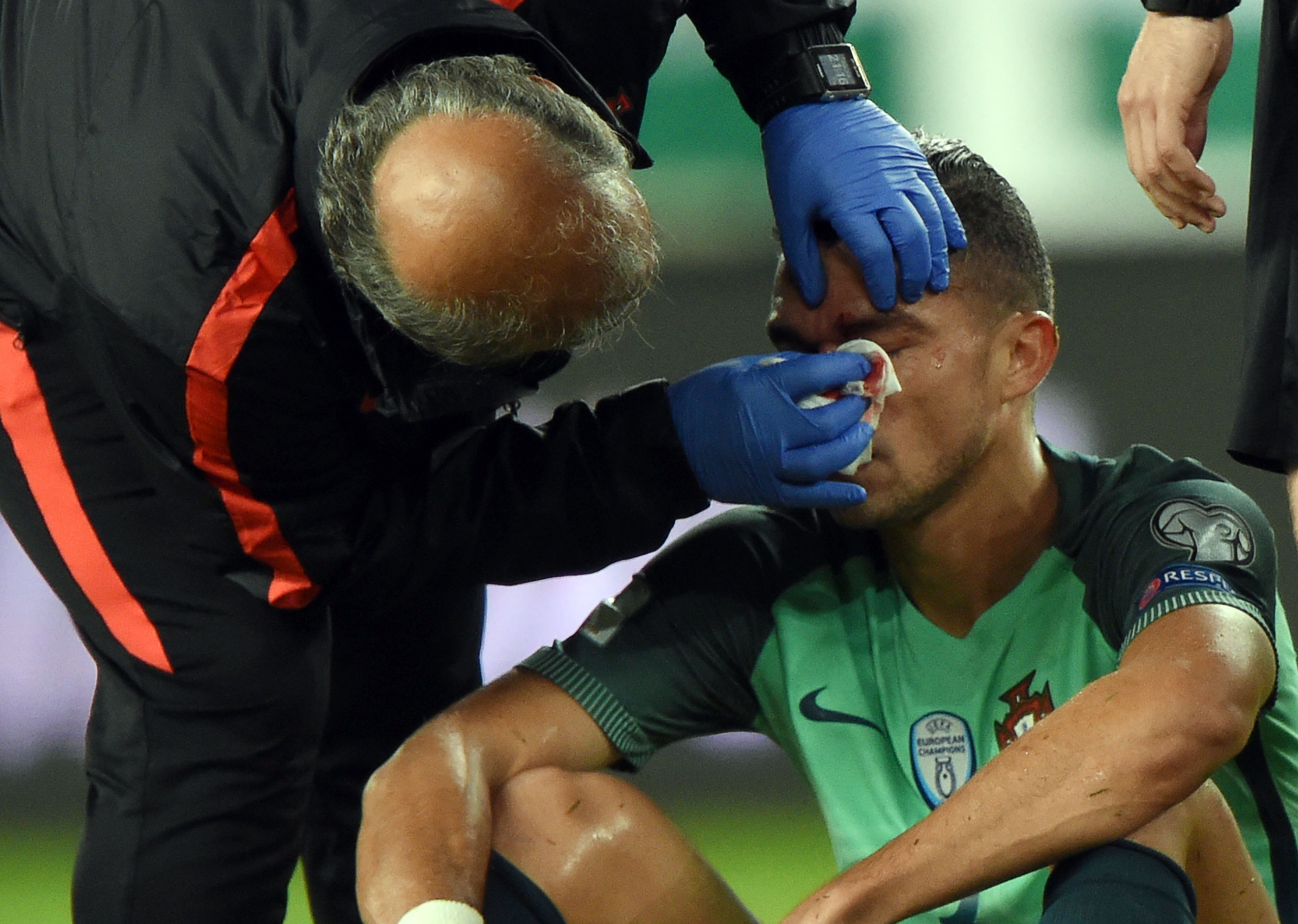Portugal's Pepe is helped by a doctor during the FIFA World Cup 2018 qualification football match between Hungary and Portugal in Budapest on September 3, 2017. / AFP PHOTO / ATTILA KISBENEDEK        (Photo credit should read ATTILA KISBENEDEK/AFP/Getty Images)