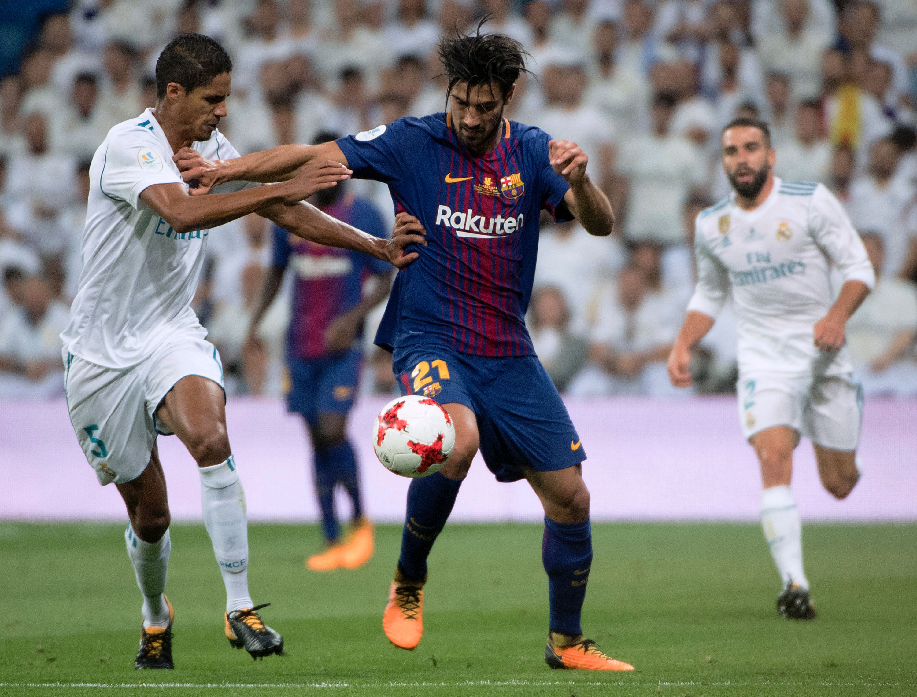 Real Madrid's French defender Raphael Varane (L) vies with Barcelona's Portuguese midfielder Andre Gomes during the second leg of the Spanish Supercup football match Real Madrid vs FC Barcelona at the Santiago Bernabeu stadium in Madrid, on August 16, 2017. / AFP PHOTO / CURTO DE LA TORRE        (Photo credit should read CURTO DE LA TORRE/AFP/Getty Images)