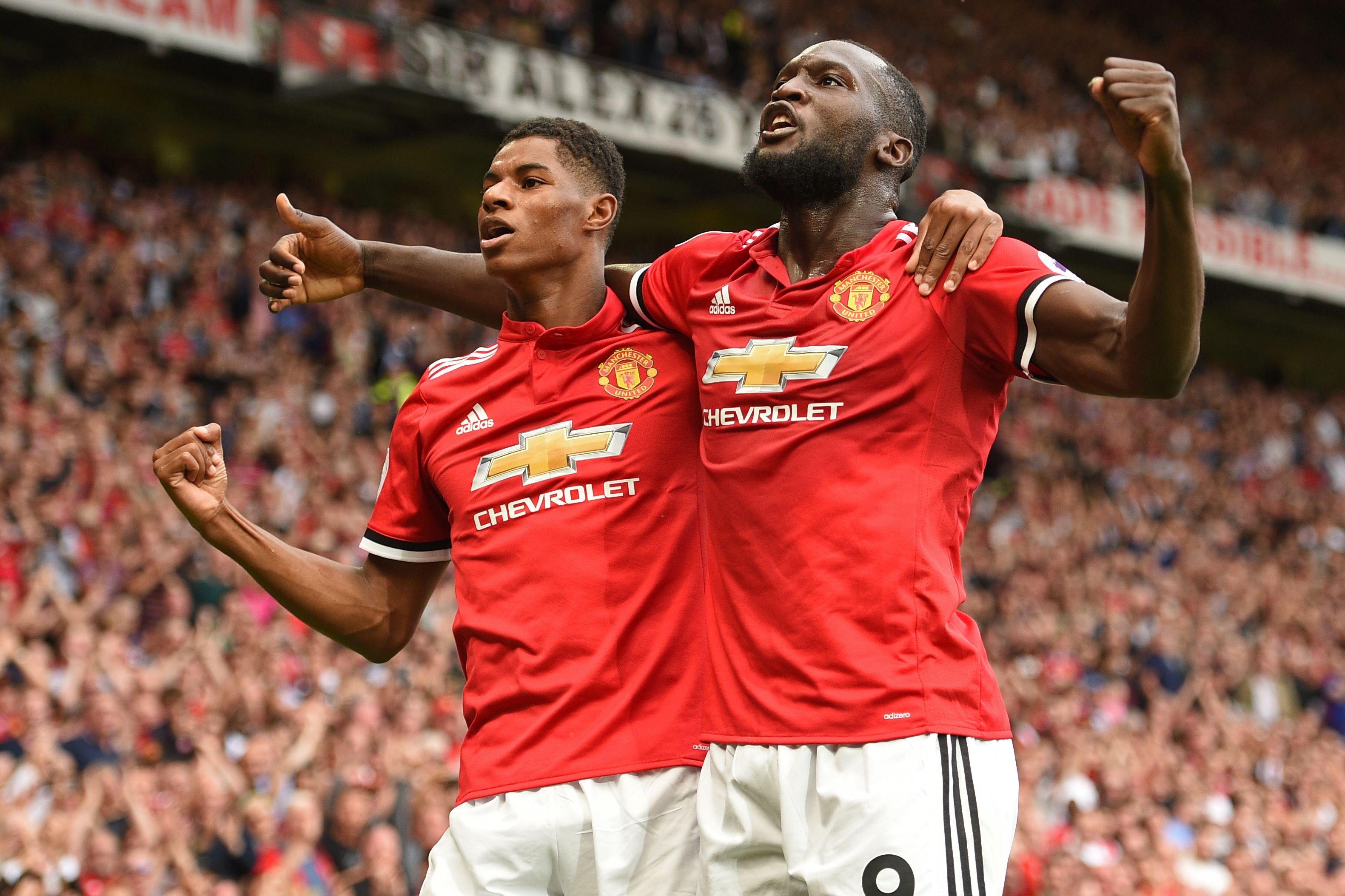 Manchester United's Belgian striker Romelu Lukaku celebrates scoring the opening goal with Manchester United's English striker Marcus Rashford during the English Premier League football match between Manchester United and West Ham United at Old Trafford in Manchester, north west England, on August 13, 2017. / AFP PHOTO / Oli SCARFF / RESTRICTED TO EDITORIAL USE. No use with unauthorized audio, video, data, fixture lists, club/league logos or 'live' services. Online in-match use limited to 75 images, no video emulation. No use in betting, games or single club/league/player publications.  /         (Photo credit should read OLI SCARFF/AFP/Getty Images)
