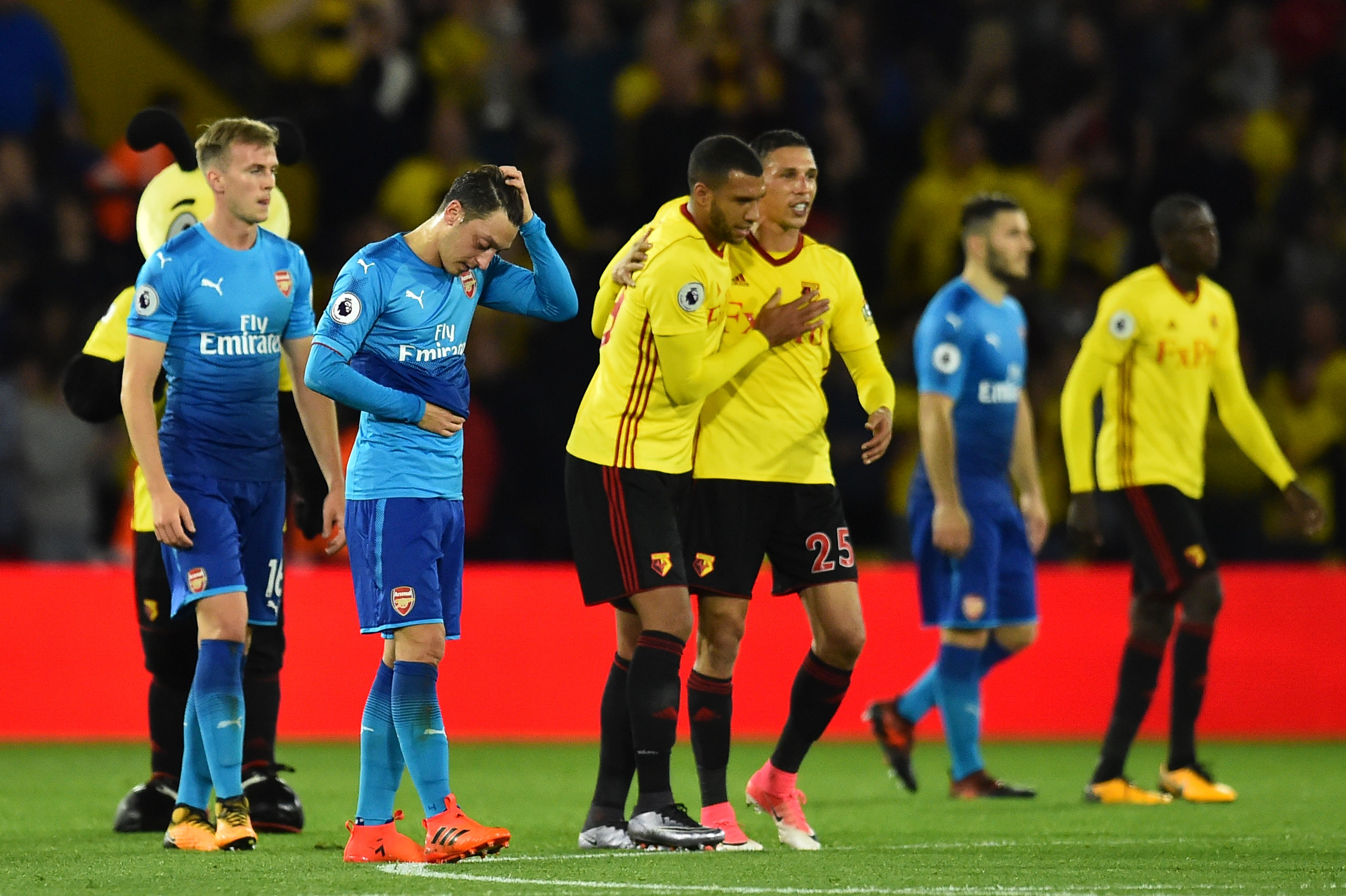Arsenal's German midfielder Mesut Ozil (2L) reacts at the final whistle as Watford's English striker Troy Deeney (CL) and Watford's German-born Greek midfielder José Holebas (CR) during the English Premier League football match between Watford and Arsenal at Vicarage Road Stadium in Watford, north of London on October 14, 2017.
Watford won 2-1. / AFP PHOTO / Glyn KIRK / RESTRICTED TO EDITORIAL USE. No use with unauthorized audio, video, data, fixture lists, club/league logos or 'live' services. Online in-match use limited to 75 images, no video emulation. No use in betting, games or single club/league/player publications.  /         (Photo credit should read GLYN KIRK/AFP/Getty Images)