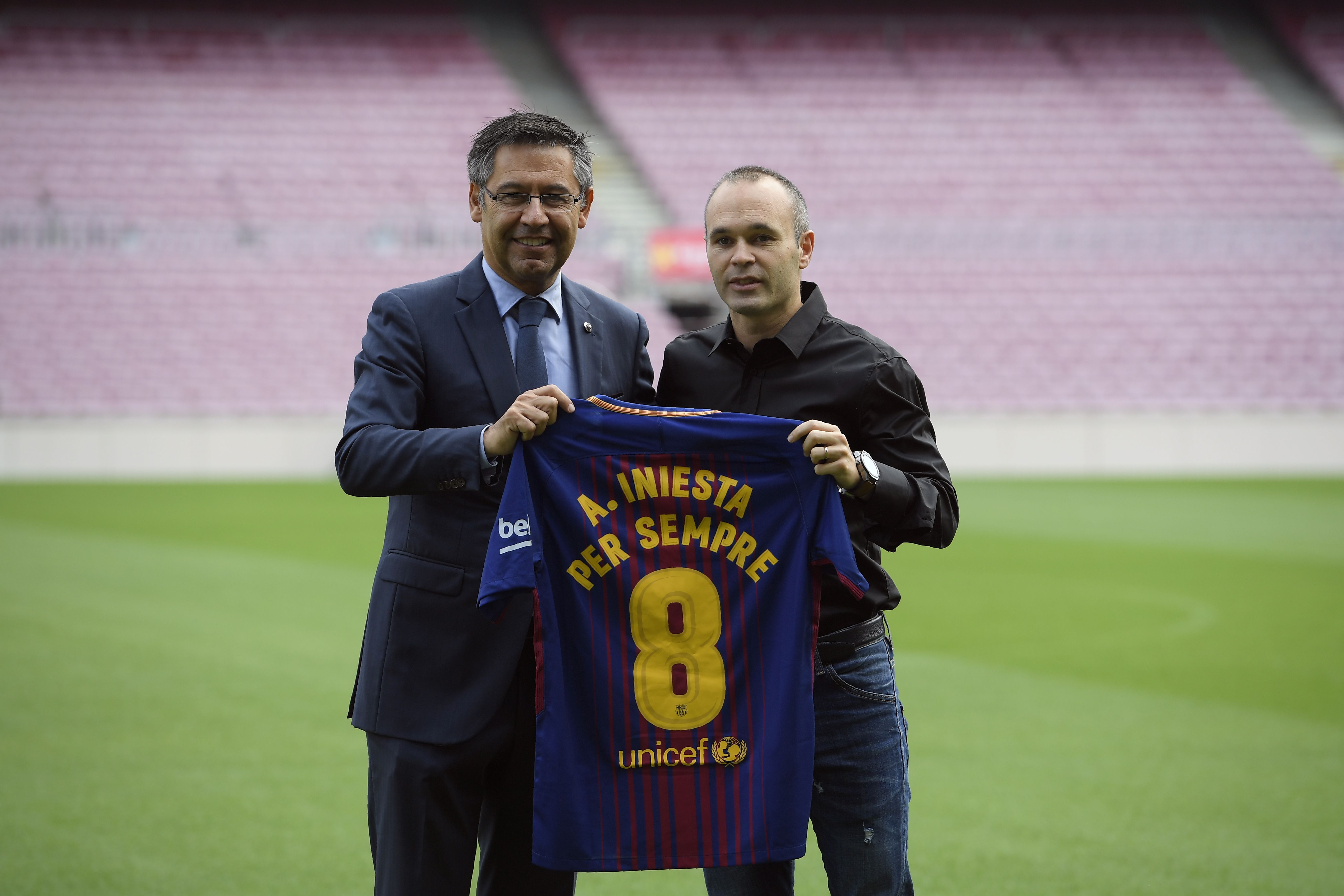 Barcelona's midfielder Andres Iniesta poses with a special Barcelona FC jersey next to the Catalan club's president Josep Maria Bartomeu (L) after renewing his contract at the Camp Nou in Barcelona on October 6, 2017.
Barcelona tied down captain Andres Iniesta for the rest of his career as the club announced the 33-year-old midfielder has agreed a "lifetime contract". Normally determined to shy away from the spotlight, Iniesta spoke out to urge negotiation and prevent a spiralling political crisis over the battle for Catalan independence deepening. / AFP PHOTO / LLUIS GENE        (Photo credit should read LLUIS GENE/AFP/Getty Images)