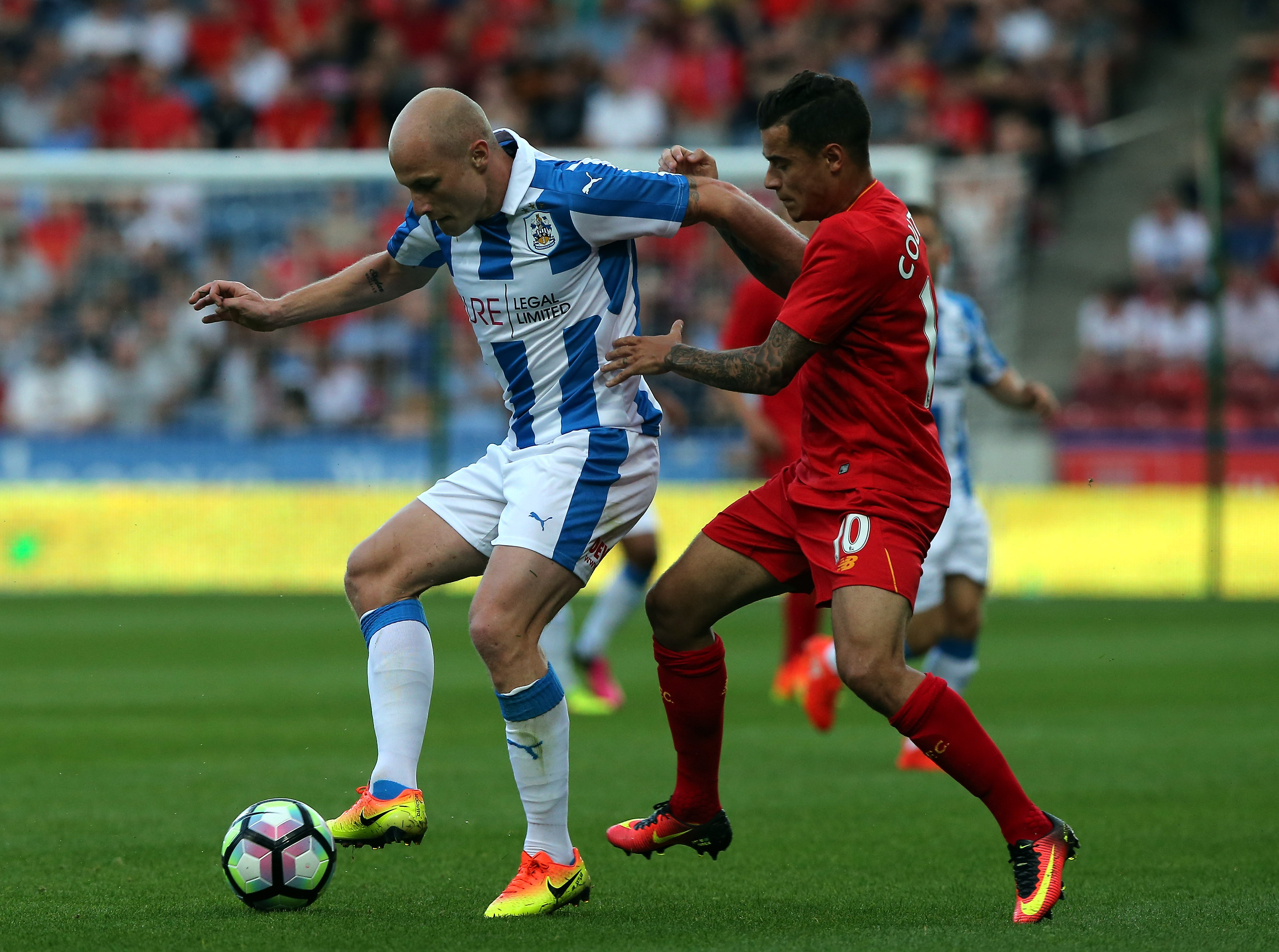 HUDDERSFIELD, ENGLAND - JULY 20:  Aaron Mooy (L) of Huddersfield Town challenged by Philippe Coutinho of Liverpool during the  Pre-Season Friendly match between Huddersfield Town and Liverpool at the Galpharm Stadium on July 20, 2016 in Huddersfield, England.  (Photo by Nigel Roddis/Getty Images)