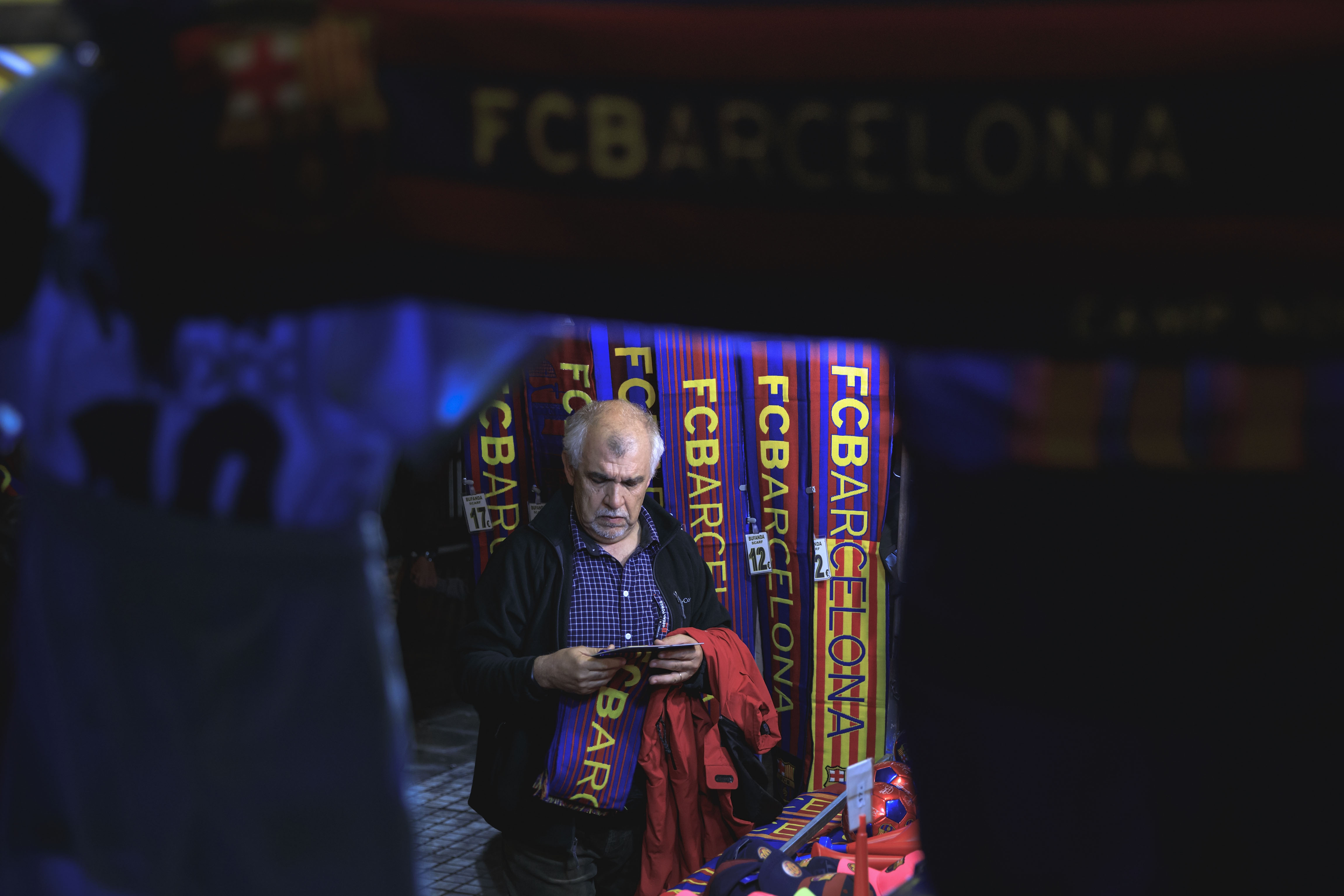 BARCELONA, SPAIN - NOVEMBER 04: A man buys a FC Barcelona scarf at a merchandaisng stall before the La Liga match between FC Barcelona and Sevilla FC at Camp Nou stadium on November 4, 2017 in Barcelona, Spain.  (Photo by Gonzalo Arroyo Moreno/Getty Images)