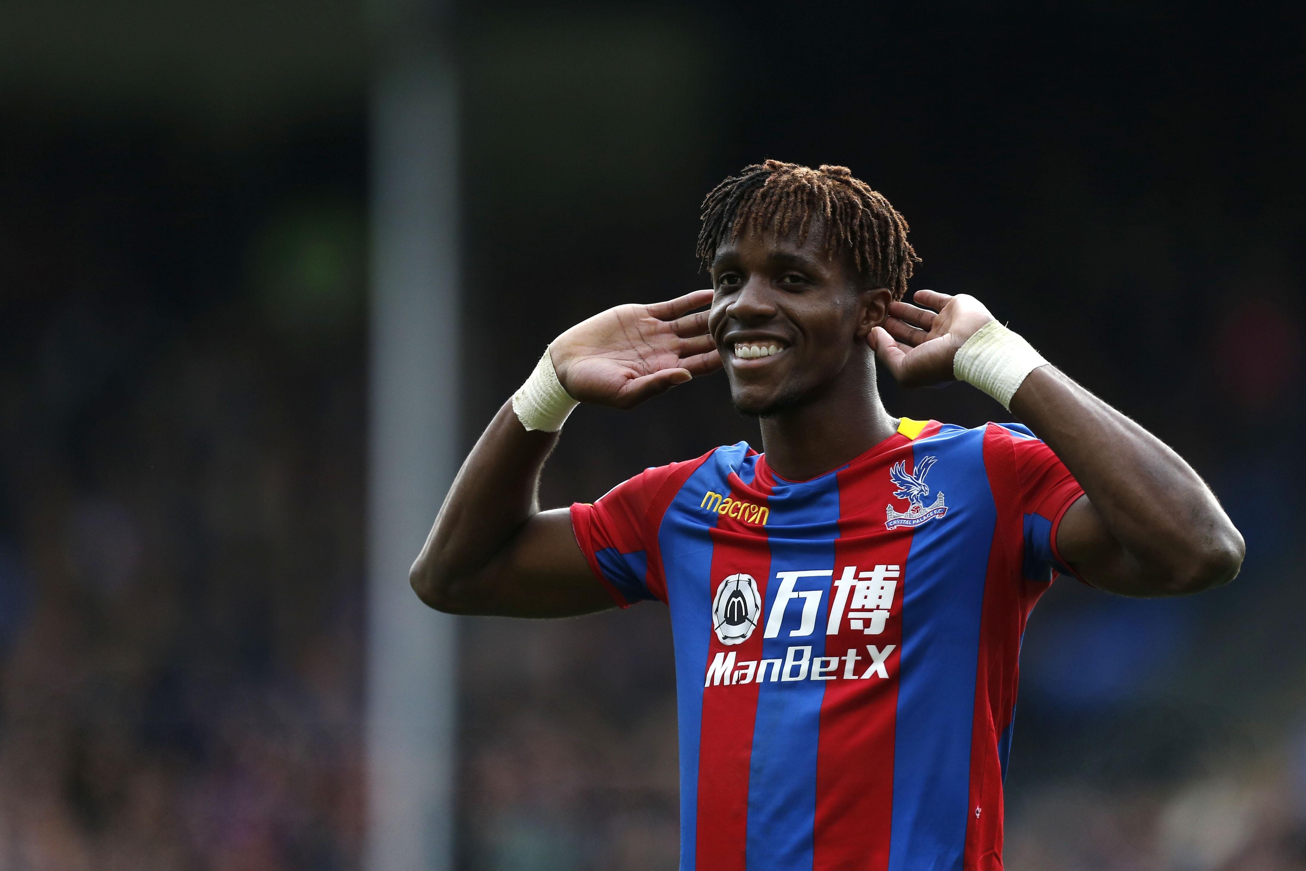 Crystal Palace's Ivorian striker Wilfried Zaha gestures to supporters during the English Premier League football match between Crystal Palace and West Ham United at Selhurst Park in south London on October 28, 2017. / AFP PHOTO / Ian KINGTON / RESTRICTED TO EDITORIAL USE. No use with unauthorized audio, video, data, fixture lists, club/league logos or 'live' services. Online in-match use limited to 75 images, no video emulation. No use in betting, games or single club/league/player publications.  /         (Photo credit should read IAN KINGTON/AFP/Getty Images)