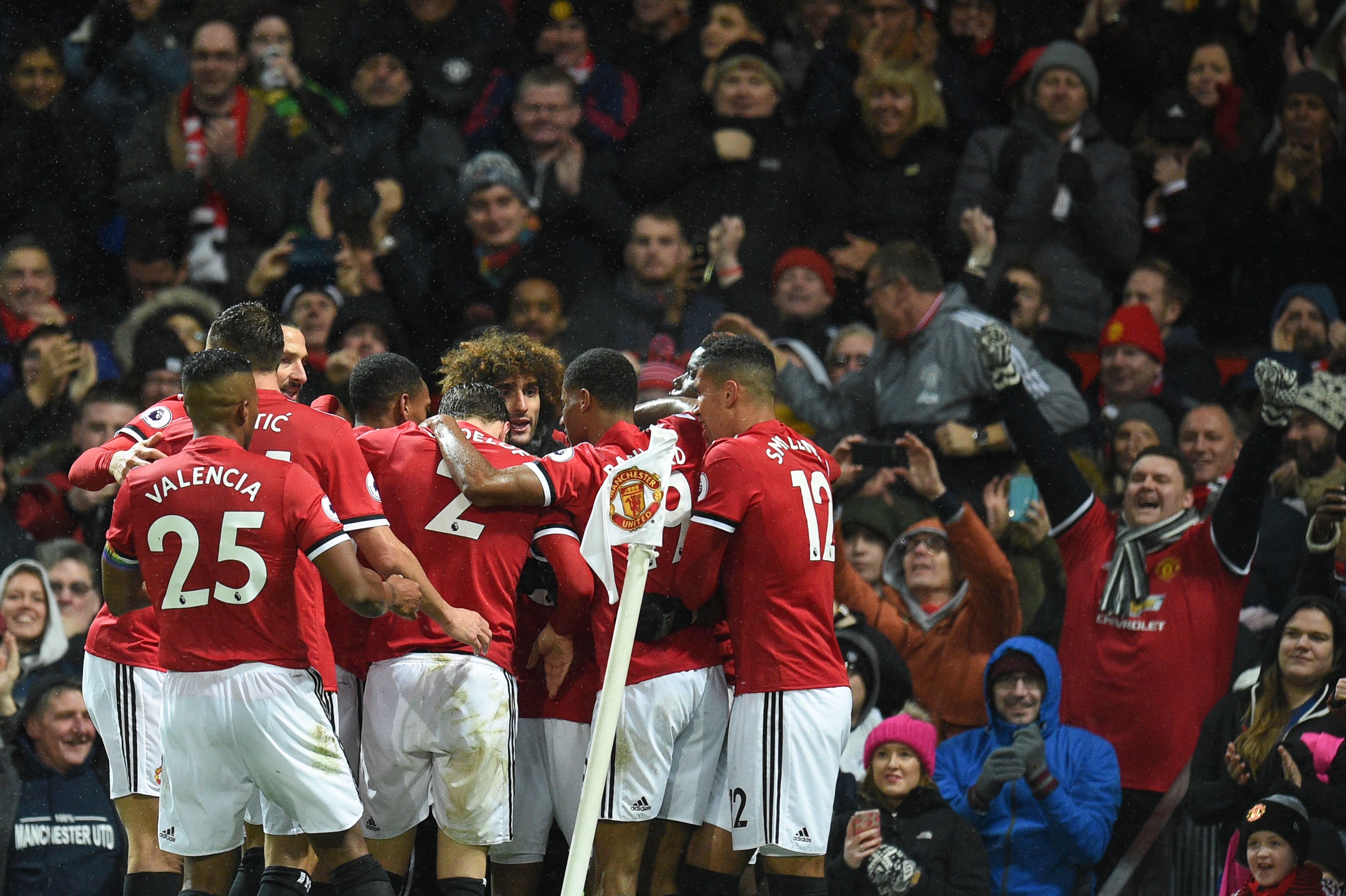 Manchester United players celebrate after Manchester United's English midfielder Ashley Young scored the opening goal during the English Premier League football match between Manchester United and Brighton and Hove Albion at Old Trafford in Manchester, north west England, on November 25, 2017. / AFP PHOTO / Oli SCARFF / RESTRICTED TO EDITORIAL USE. No use with unauthorized audio, video, data, fixture lists, club/league logos or 'live' services. Online in-match use limited to 75 images, no video emulation. No use in betting, games or single club/league/player publications.  /         (Photo credit should read OLI SCARFF/AFP/Getty Images)
