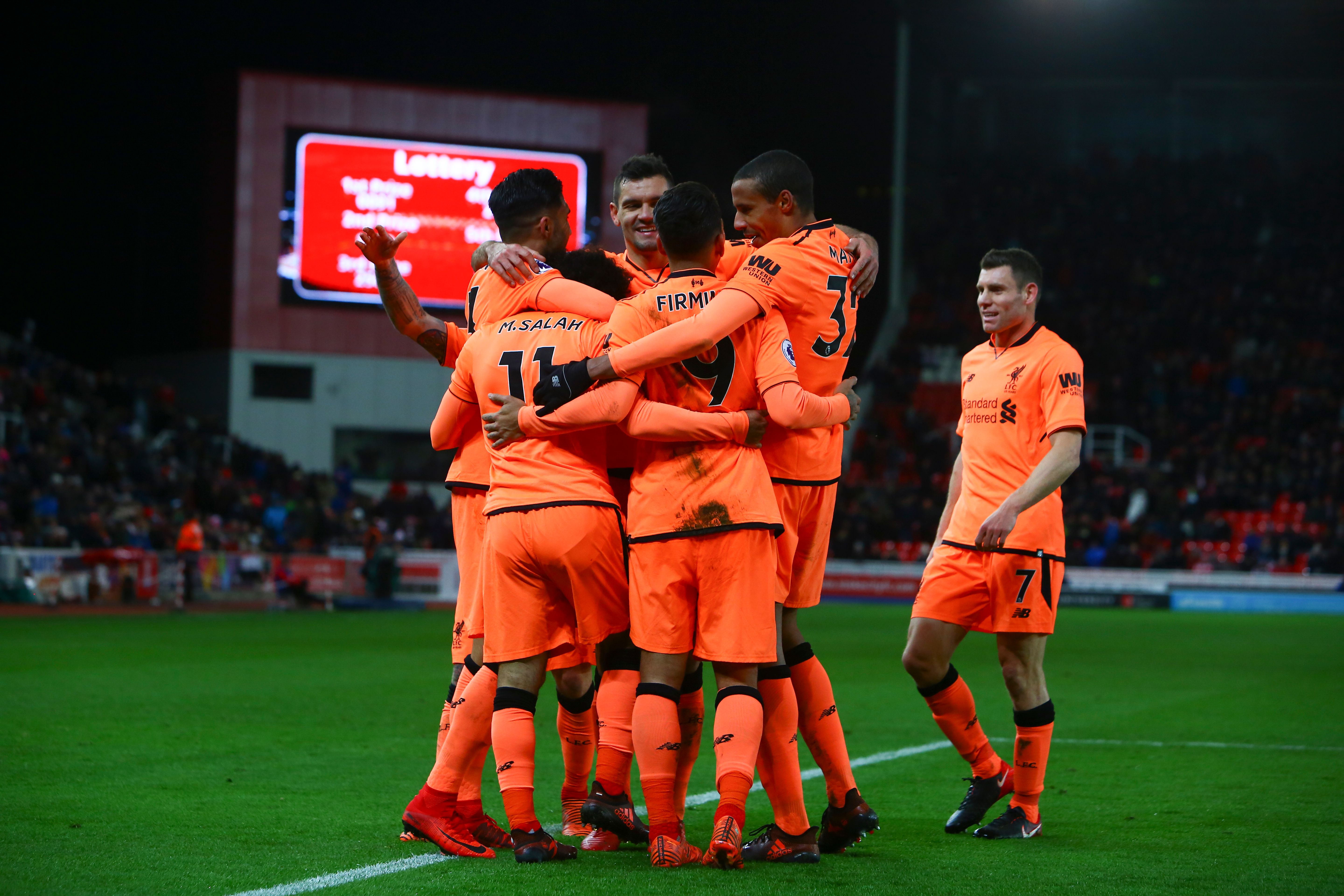 Liverpool's Egyptian midfielder Mohamed Salah celebrates with teammates after scoring their third goal during the English Premier League football match between Stoke City and Liverpool at the Bet365 Stadium in Stoke-on-Trent, central England on November 29, 2017. / AFP PHOTO / Geoff CADDICK / RESTRICTED TO EDITORIAL USE. No use with unauthorized audio, video, data, fixture lists, club/league logos or 'live' services. Online in-match use limited to 75 images, no video emulation. No use in betting, games or single club/league/player publications.  /         (Photo credit should read GEOFF CADDICK/AFP/Getty Images)