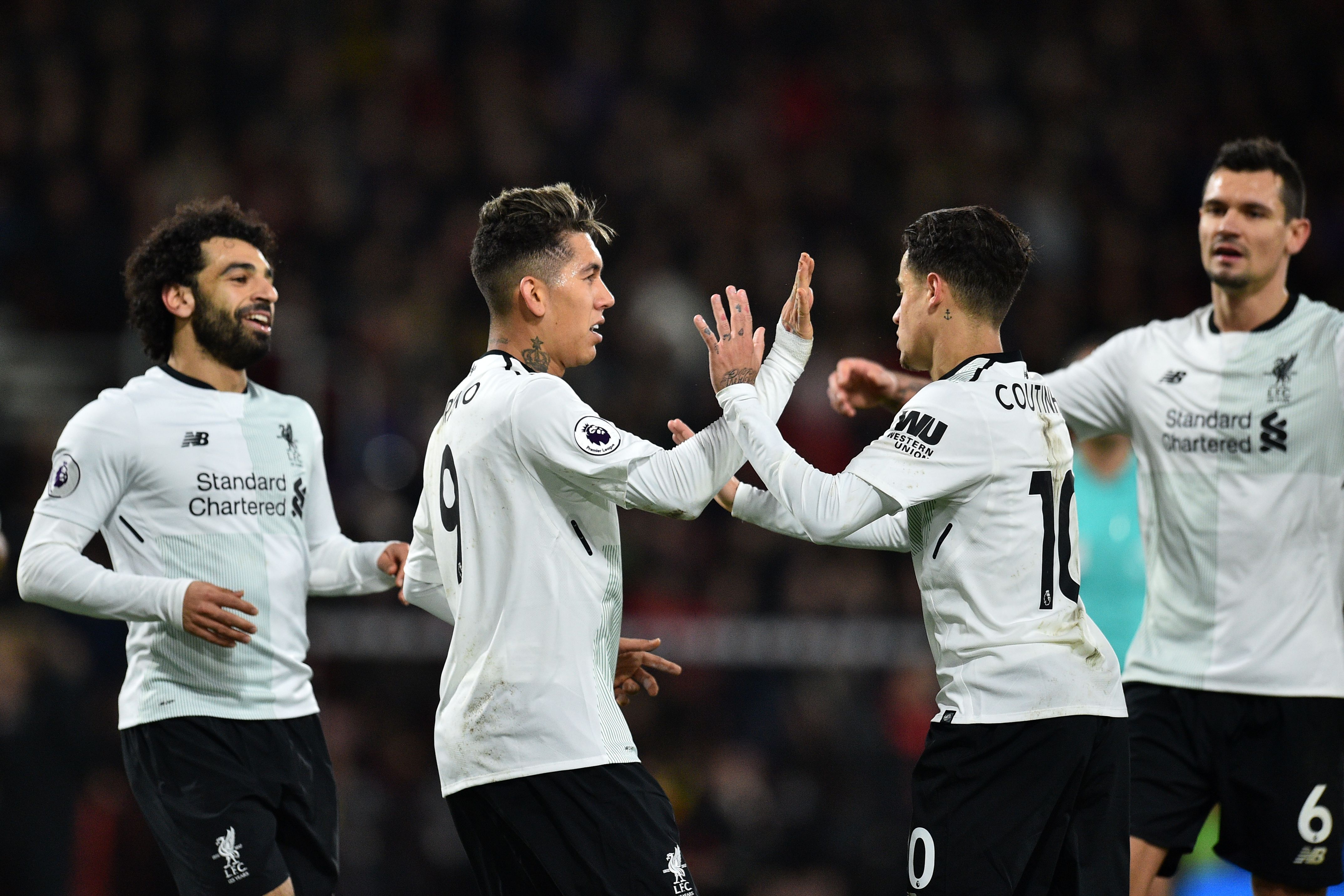 Liverpool's Brazilian midfielder Roberto Firmino (2nd L) celebrates with the game's other goal-scoreres, Liverpool's Egyptian midfielder Mohamed Salah (L), Liverpool's Brazilian midfielder Philippe Coutinho (2nd R) and Liverpool's Croatian defender Dejan Lovren (R) after scoring their fourth goal during the English Premier League football match between Bournemouth and Liverpool at the Vitality Stadium in Bournemouth, southern England on December 17, 2017. / AFP PHOTO / Glyn KIRK / RESTRICTED TO EDITORIAL USE. No use with unauthorized audio, video, data, fixture lists, club/league logos or 'live' services. Online in-match use limited to 75 images, no video emulation. No use in betting, games or single club/league/player publications.  /         (Photo credit should read GLYN KIRK/AFP/Getty Images)