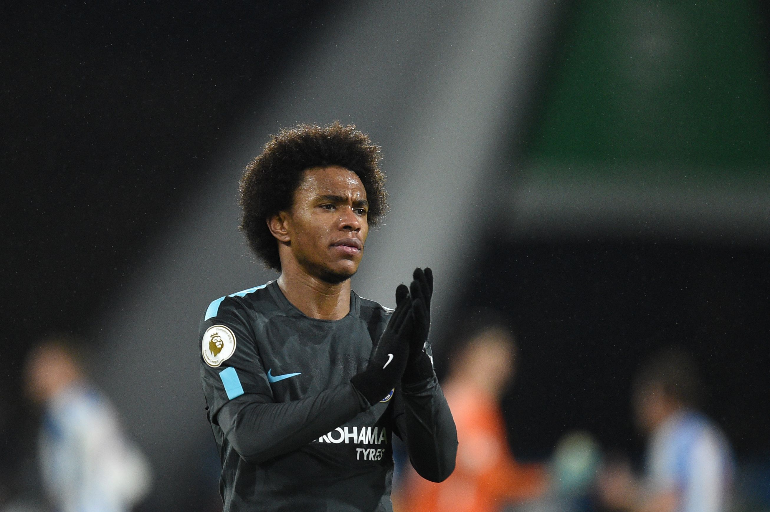 Chelsea's Brazilian midfielder Willian applauds fans after winning the English Premier League football match between Huddersfield Town and Chelsea at the John Smith's stadium in Huddersfield, northern England on December 12, 2017. / AFP PHOTO / Oli SCARFF / RESTRICTED TO EDITORIAL USE. No use with unauthorized audio, video, data, fixture lists, club/league logos or 'live' services. Online in-match use limited to 75 images, no video emulation. No use in betting, games or single club/league/player publications.  /         (Photo credit should read OLI SCARFF/AFP/Getty Images)