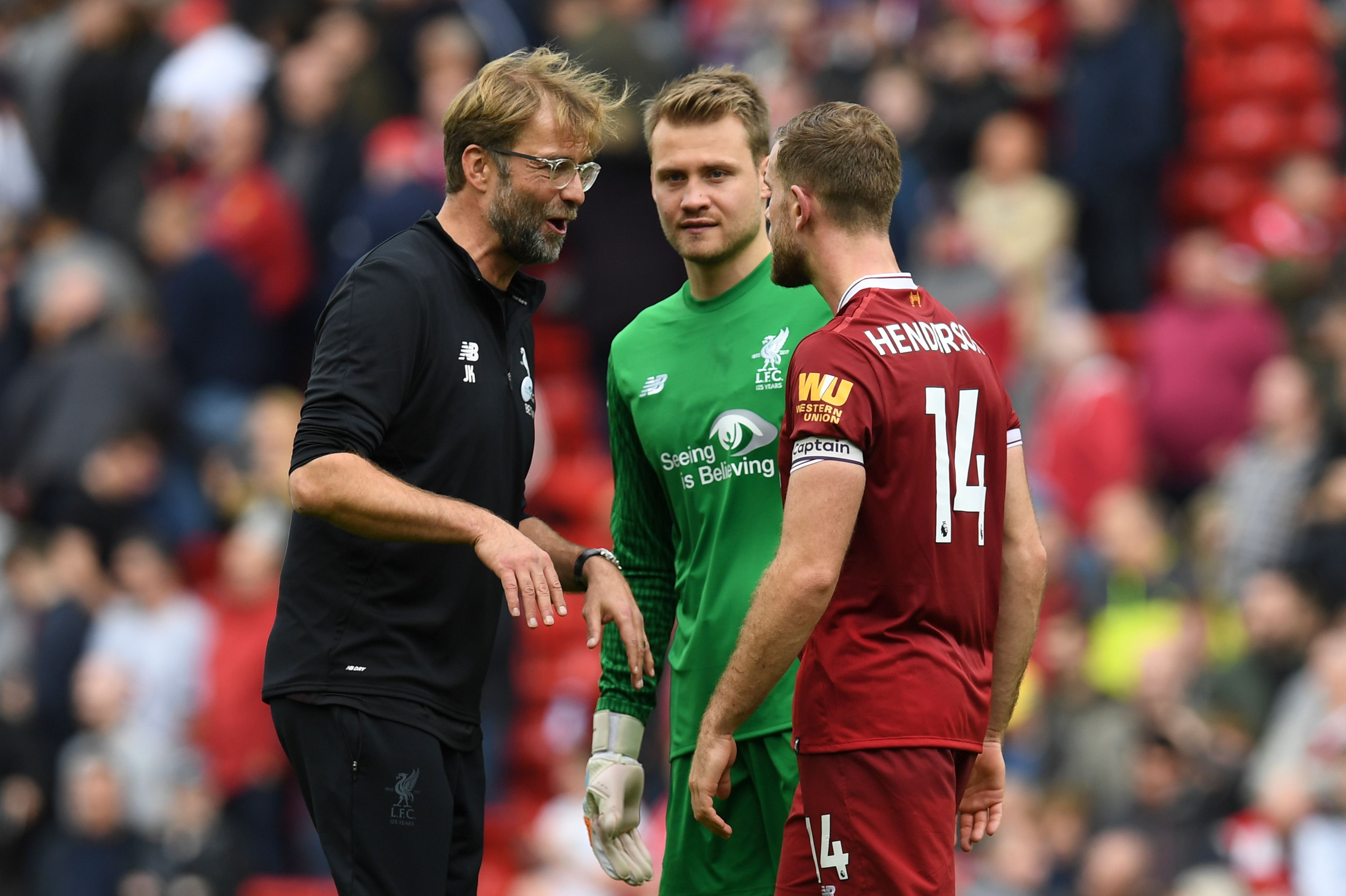 Liverpool's German manager Jurgen Klopp (L) speaks with Liverpool's Belgian goalkeeper Simon Mignolet (C) and Liverpool's English midfielder Jordan Henderson after the English Premier League football match between Liverpool and Manchester United at Anfield in Liverpool, north west England on October 14, 2017.
The game ended 0-0. / AFP PHOTO / Paul ELLIS / RESTRICTED TO EDITORIAL USE. No use with unauthorized audio, video, data, fixture lists, club/league logos or 'live' services. Online in-match use limited to 75 images, no video emulation. No use in betting, games or single club/league/player publications.  /         (Photo credit should read PAUL ELLIS/AFP/Getty Images)