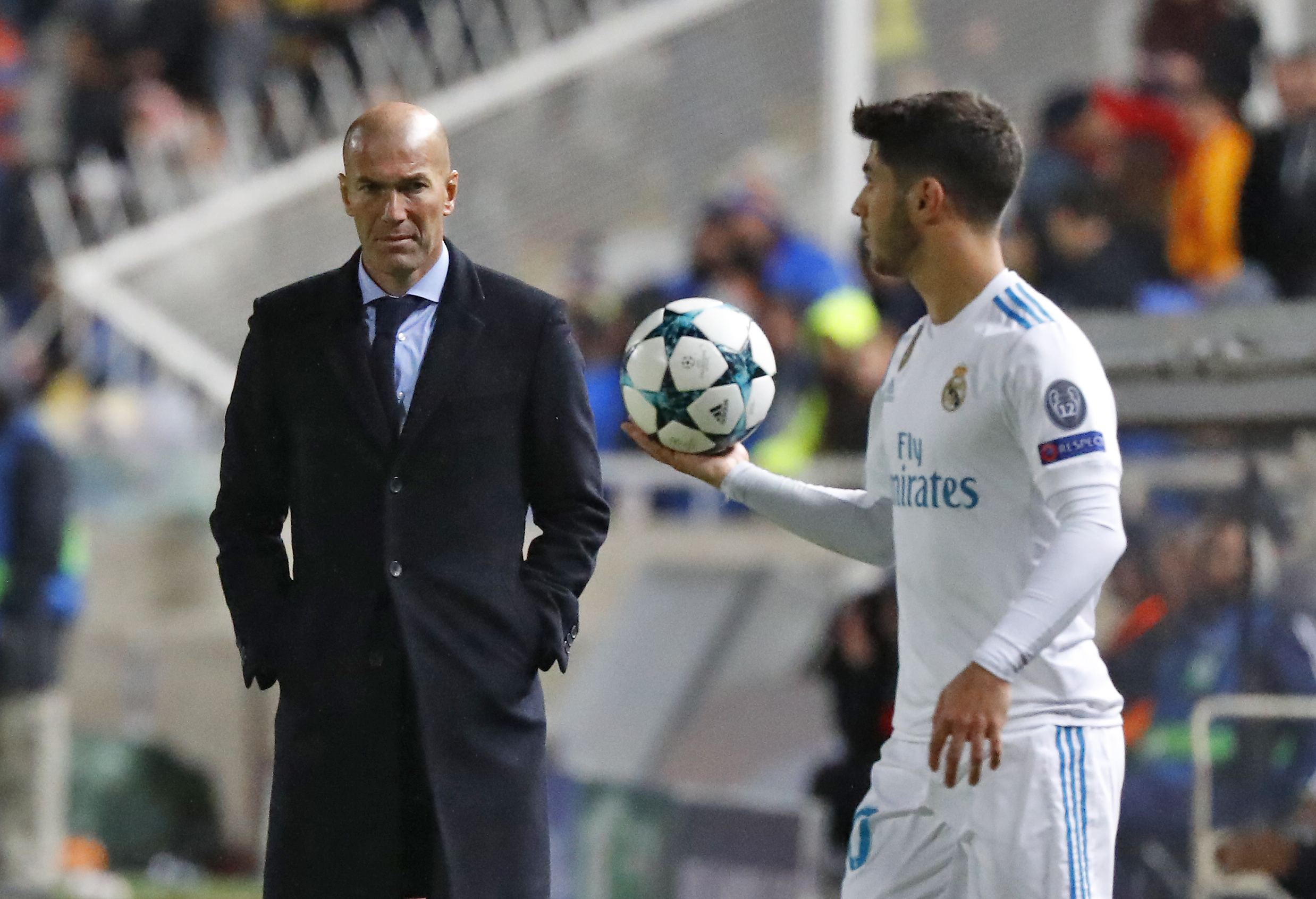 Real Madrid's Spanish midfielder Marco Asensio and Real Madrid's French head coach Zinedine Zidane are seen the UEFA Champions League Group H match between Apoel FC and Real Madrid on November 21, 2017, in the Cypriot capital Nicosia's GSP Stadium.  / AFP PHOTO / Jack GUEZ        (Photo credit should read JACK GUEZ/AFP/Getty Images)