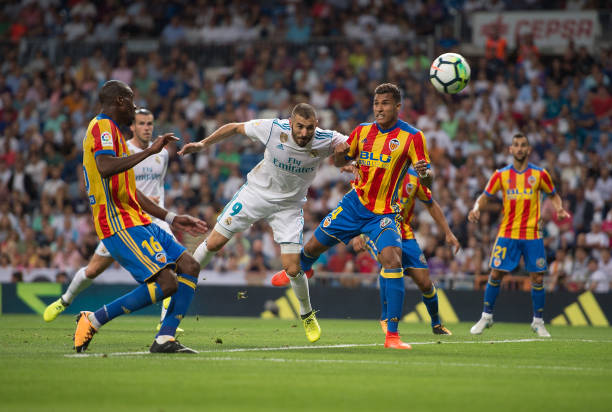 MADRID, SPAIN - AUGUST 27: Karim Benzema of Real Madrid CF heads the ball beside Jeison Murillo of Valencia CFduring the La Liga match between Real Madrid CF and Valencia CF at Estadio Santiago Bernabeu on August 27, 2017 in Madrid, Spain . (Photo by Denis Doyle/Getty Images)