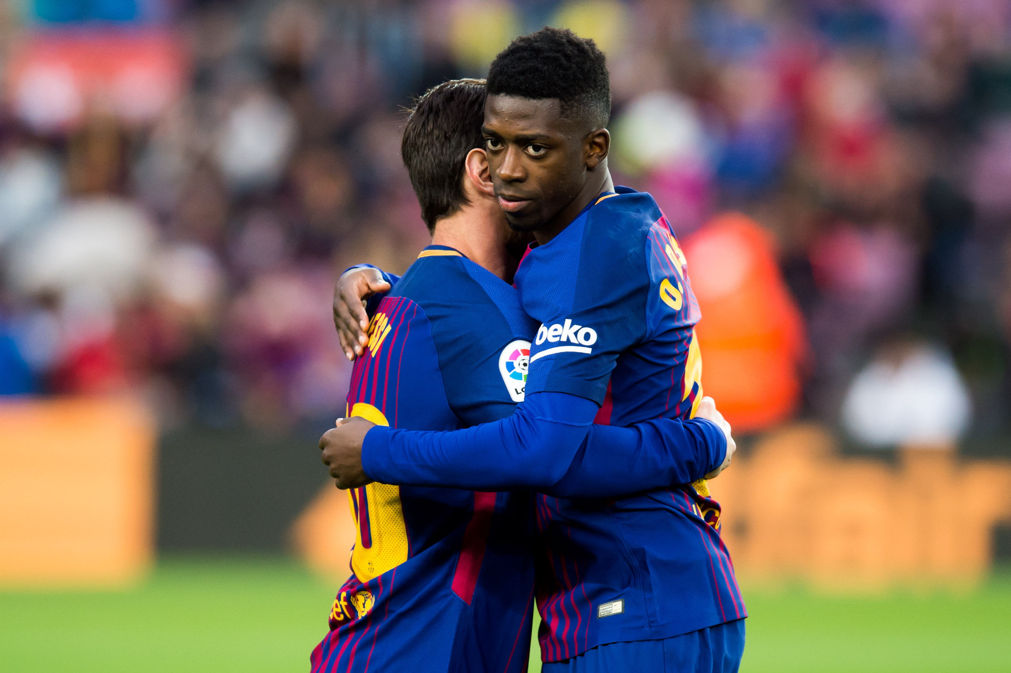 BARCELONA, SPAIN - JANUARY 07:  Ousmane Dembele of FC Barcelona embraces his teammate Lionel Messi of FC Barcelona before the La Liga match between Barcelona and Levante at Camp Nou on January 7, 2018 in Barcelona, Spain.  (Photo by Alex Caparros/Getty Images)