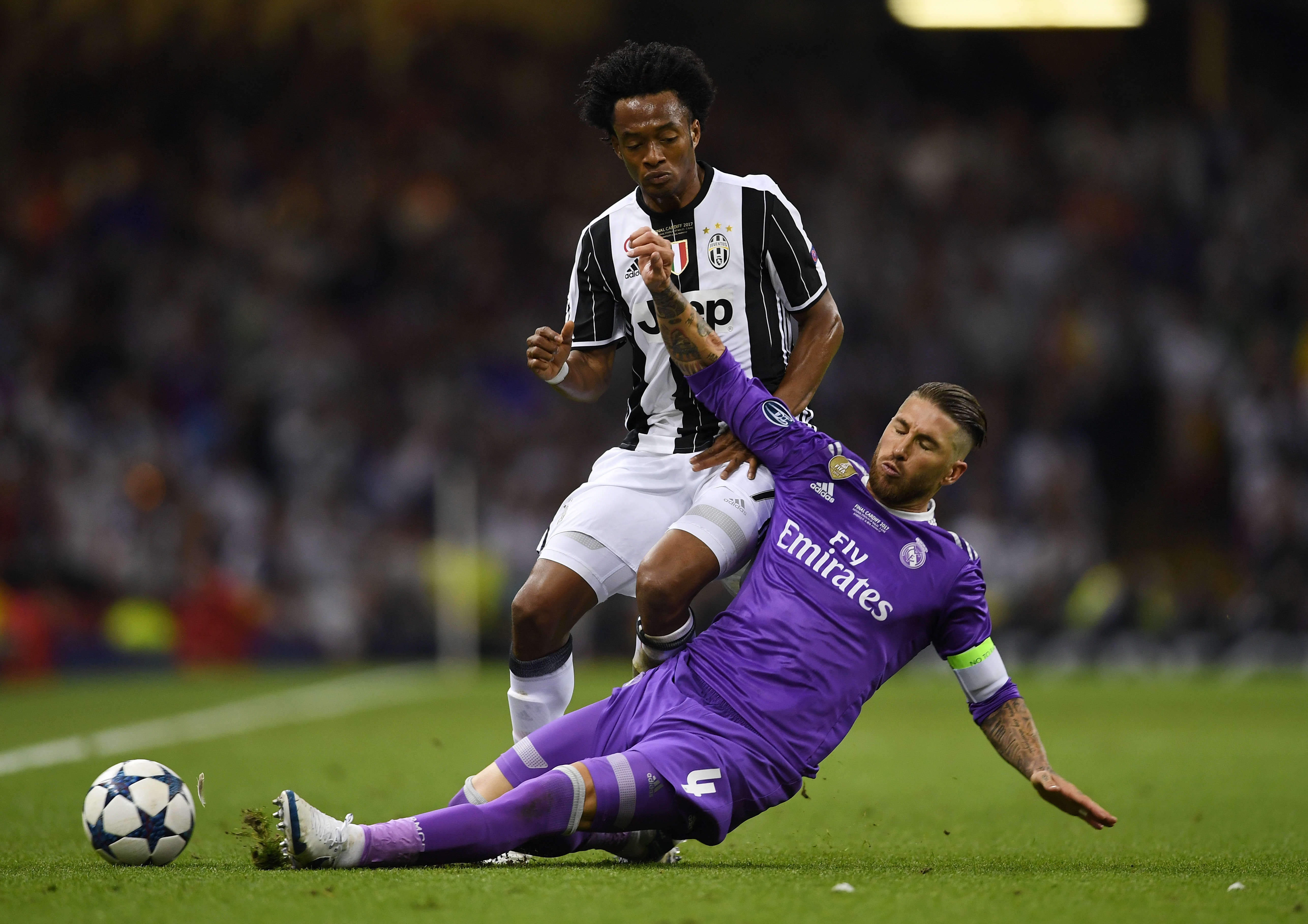 CARDIFF, WALES - JUNE 03:  Juan Cuadrado of Juventus and Sergio Ramos of Real Madrid battle for possession during the UEFA Champions League Final between Juventus and Real Madrid at National Stadium of Wales on June 3, 2017 in Cardiff, Wales.  (Photo by Shaun Botterill/Getty Images)