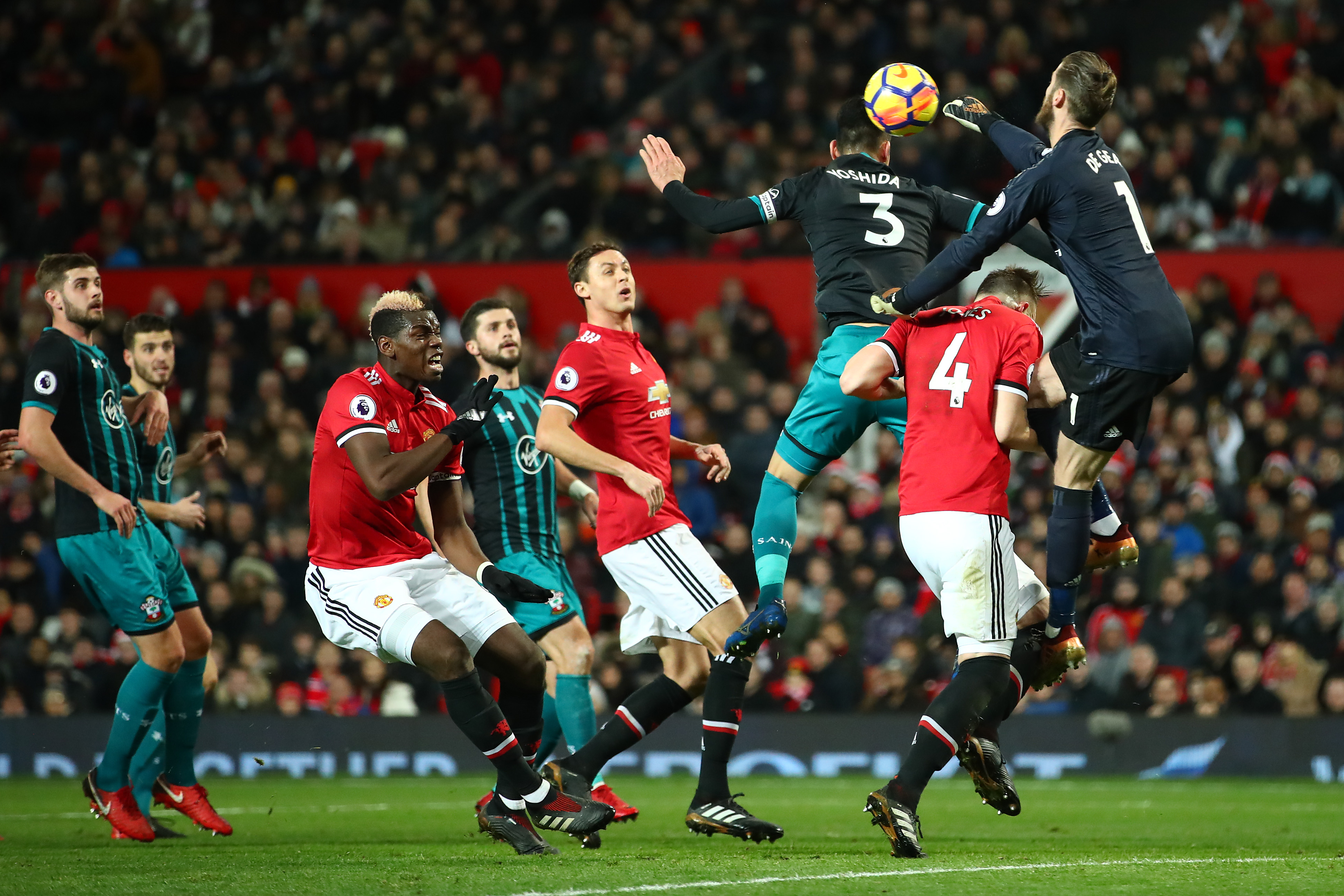 MANCHESTER, ENGLAND - DECEMBER 30:  David De Gea of Manchester United punhces clear from Maya Yoshida of Southampton during the Premier League match between Manchester United and Southampton at Old Trafford on December 30, 2017 in Manchester, England.  (Photo by Clive Mason/Getty Images)